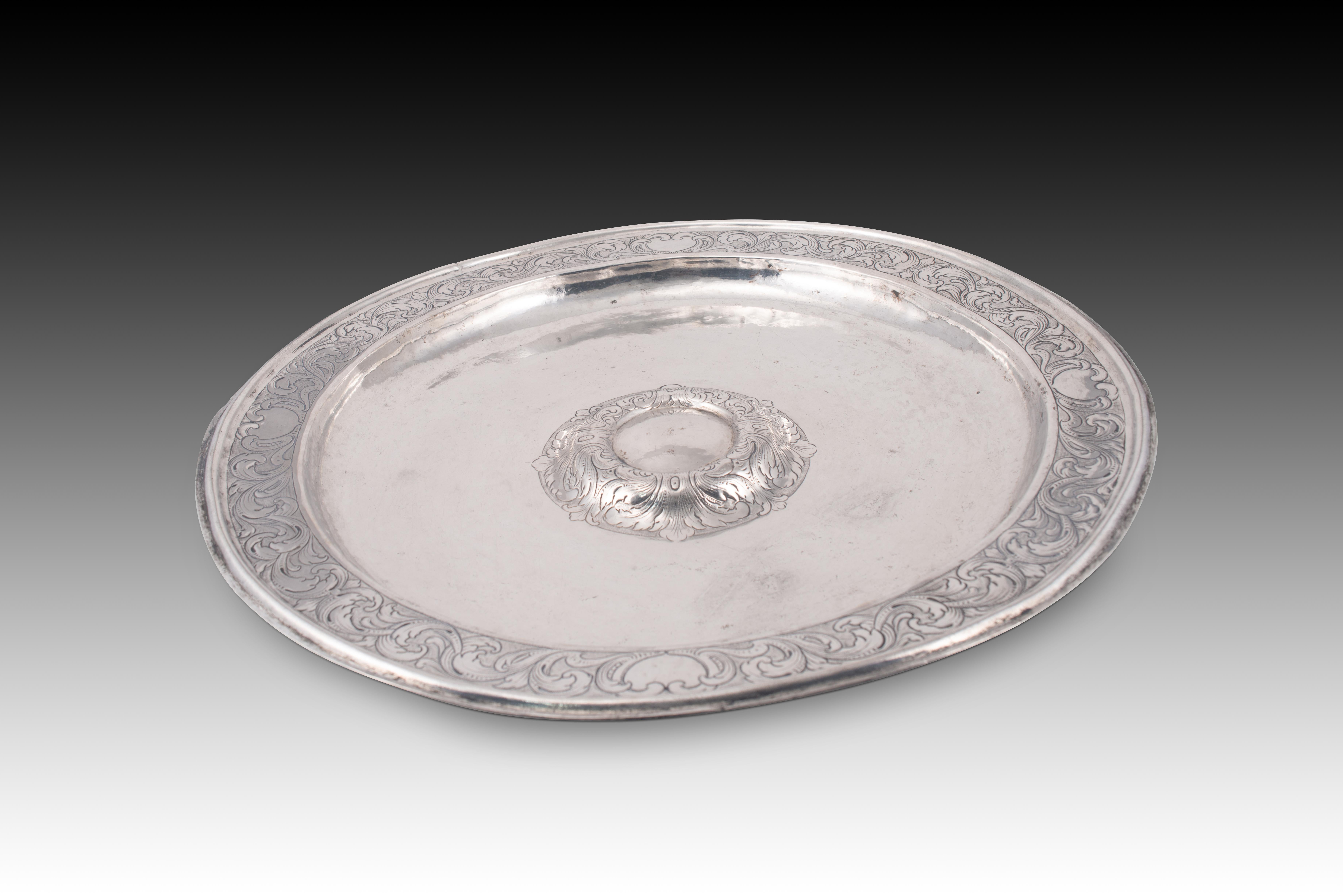  Fonte. Il colore è argento. Zaragoza, Spagna, circa 1700.
 Con marchi e segni di incisione.
 Un piatto circolare di colore argento con un bordo rialzato e decorato con una composizione di elementi vegetali e scudi o specchi piatti tra due linee di