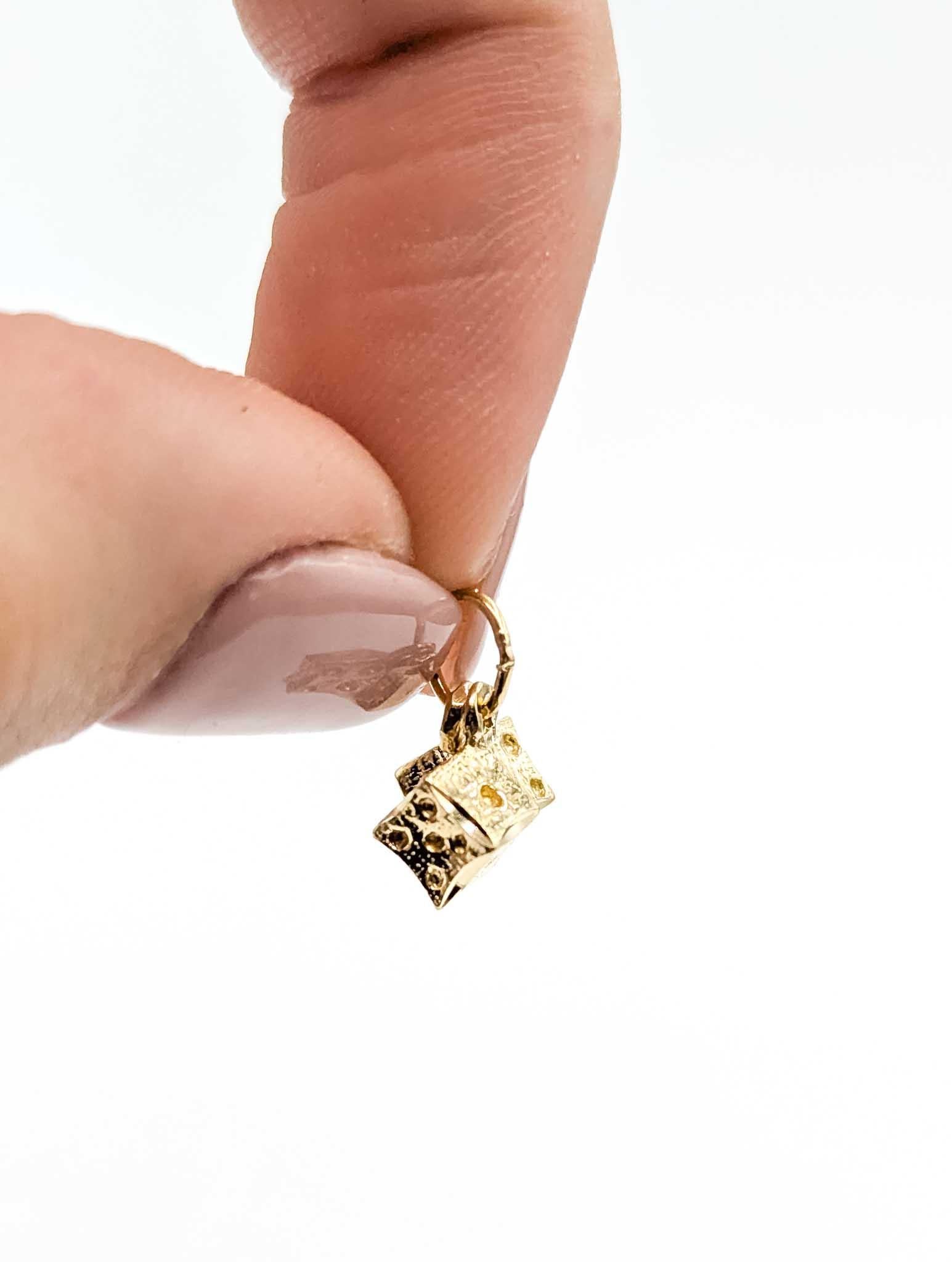 Ajoutez une touche d'amusement et de fortune à votre collection de bijoux avec ce charmant pendentif dé en or jaune 14k. Avec ses deux dés détaillés reliés entre eux par un anneau de saut mobile, cette pièce incarne à la fois la fantaisie et la