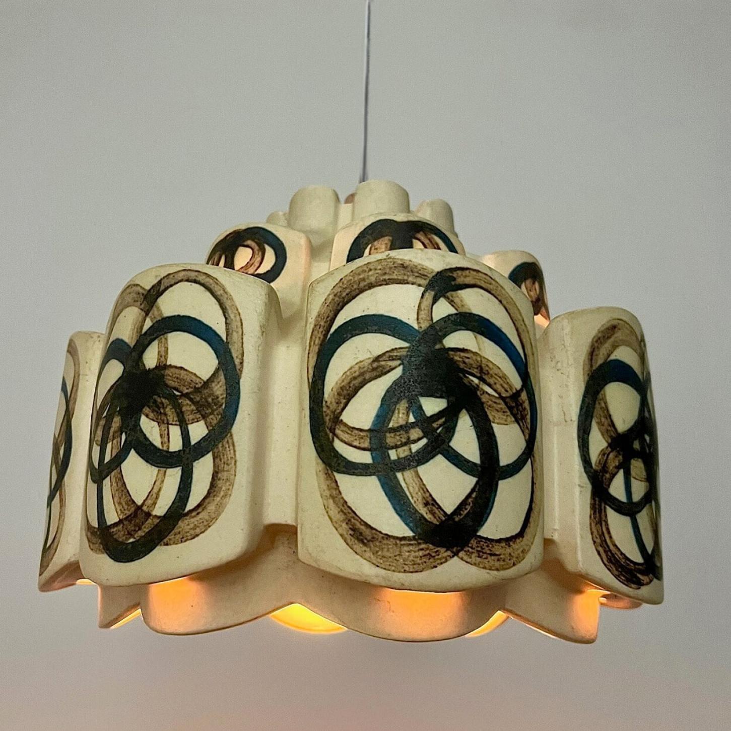 An exquisite hanging lamp with an unusual shape, made with rich colored ceramic with the shape of a flower in darker ceramic, manufactured in the 1970s in Denmark.

With beautiful fragile steel cable and wooden details. Hanging on a steel cable the
