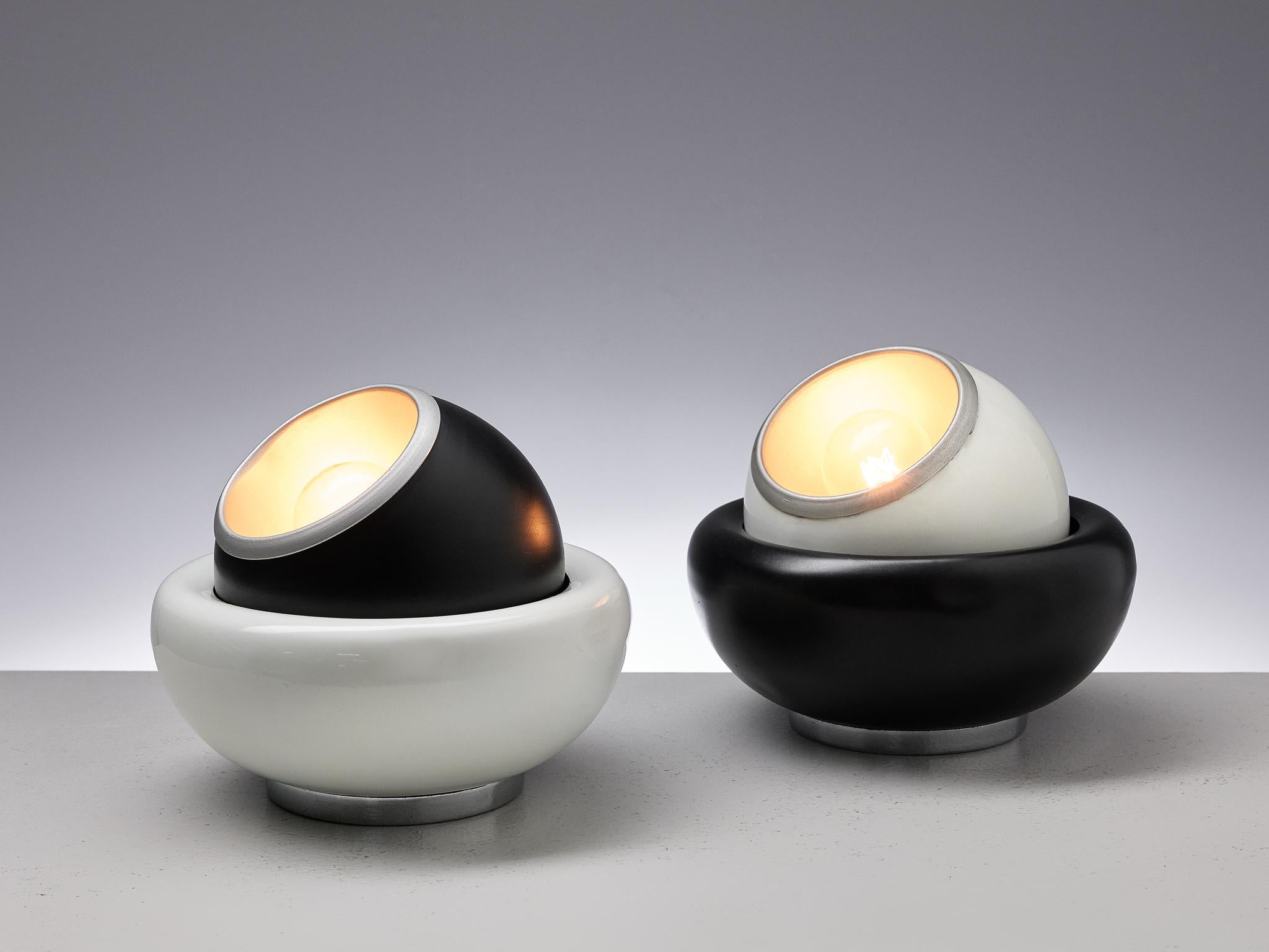Pair of table lamps, black and white lacquered metal, Italy, 1970s

A pair of postmodern table lamps in black and white lacquered metal. The lights consist of a bowl that holds the sphere, which can be rotated in any direction. With their round