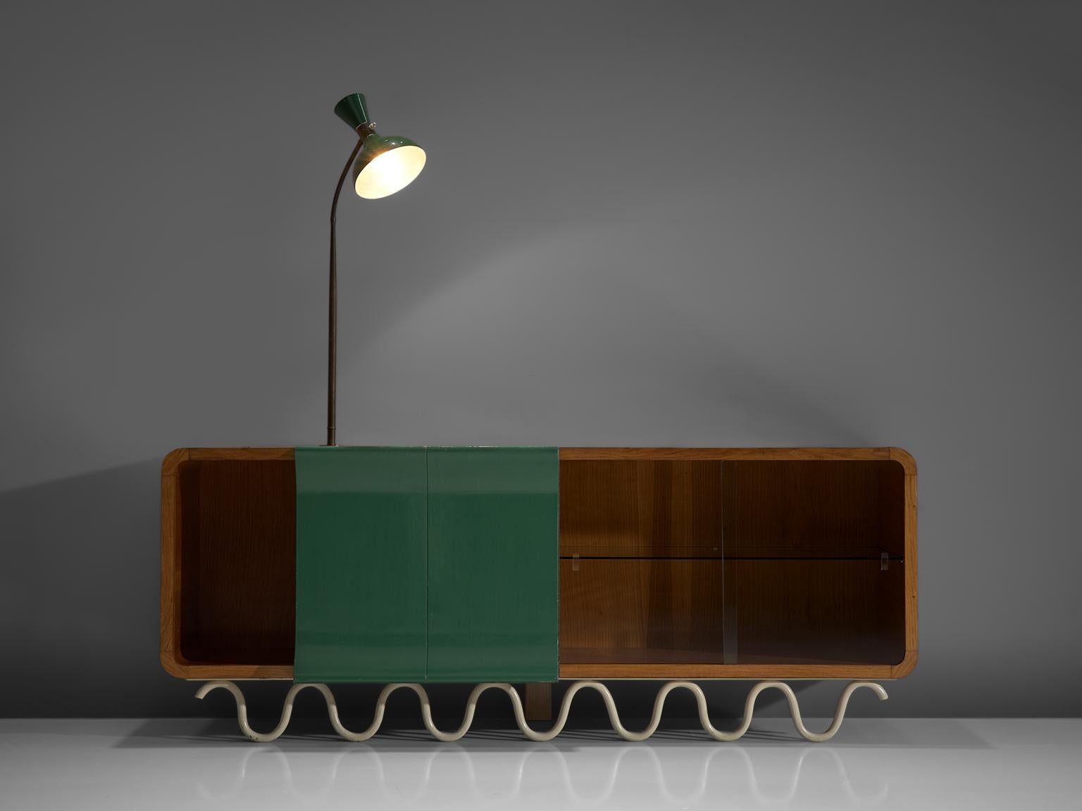 Italian sideboard with attached lamp, walnut, brass, glass, Italy, 1950s

Playful Italian walnut sideboard with green lacquered doors, and partial glass sliding doors, and on top an attached table lamp with adjustable stem. Most remarkable detail