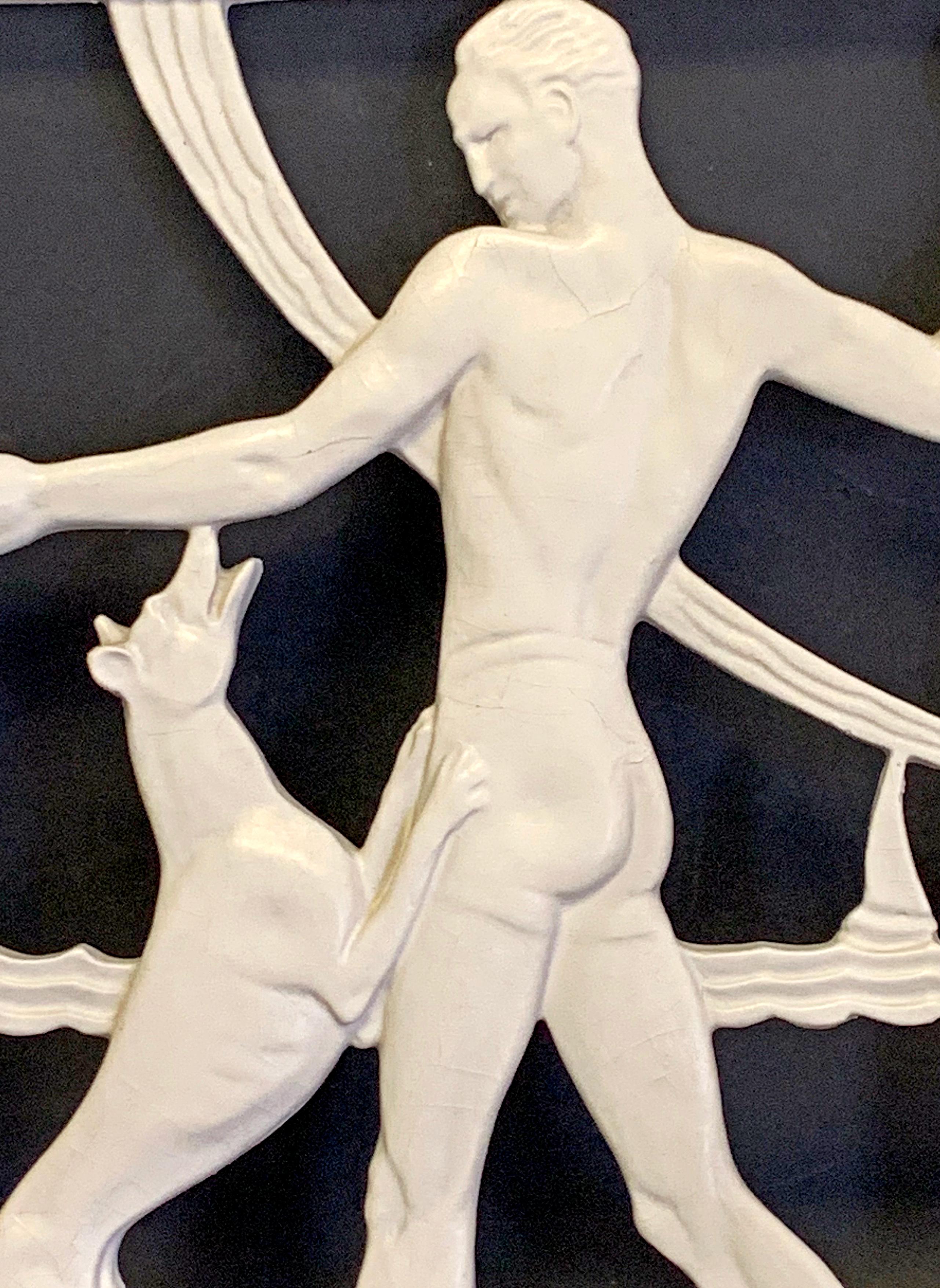 This elegant and high-style Art Deco panel, extremely rare, depicts a tall, athletic young man in a swimsuit at the beach, playing catch with his equally lithe greyhound, with a sailboat navigating Art Deco waves in the distance. This panel was