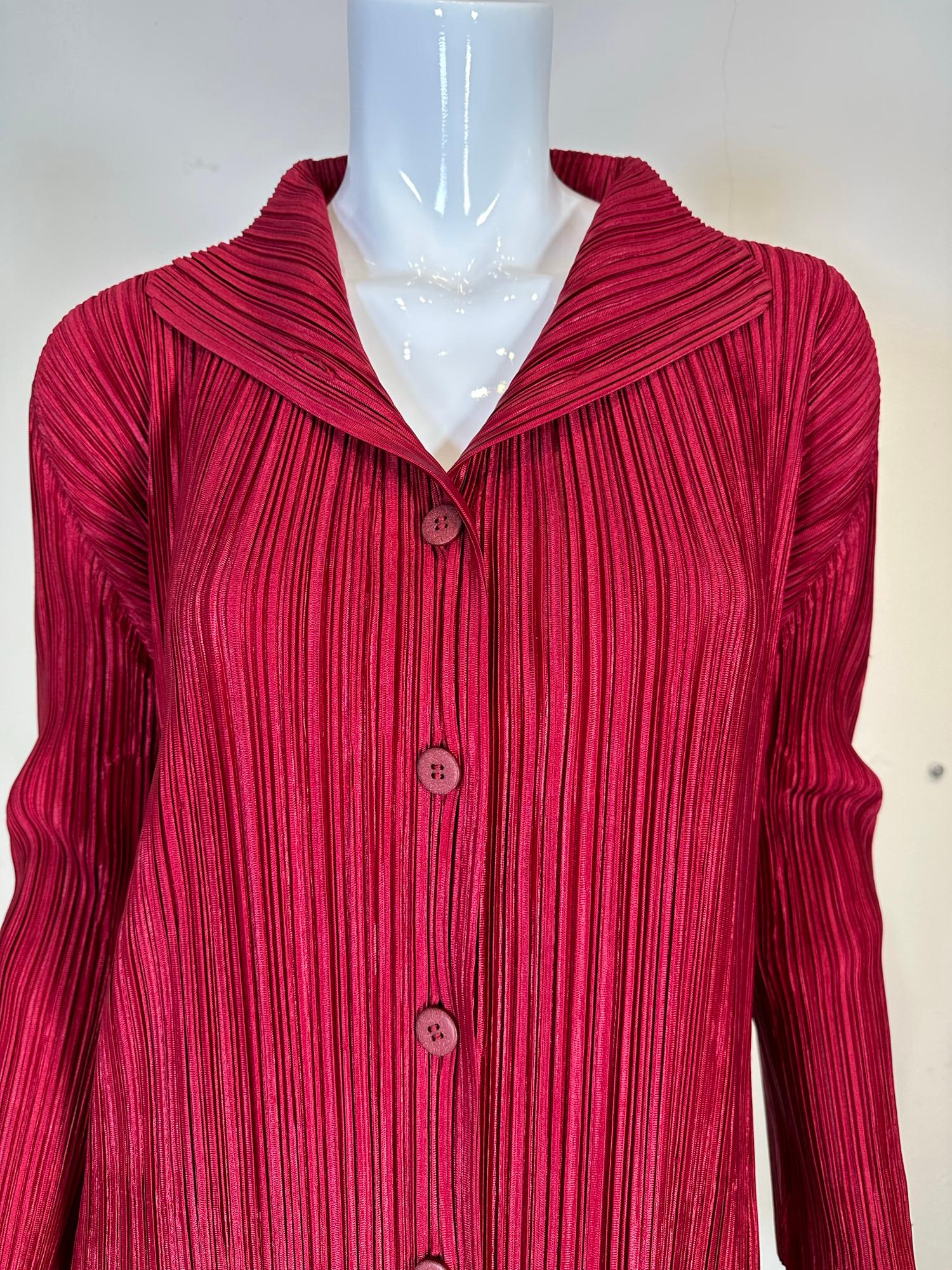 Pleats Please Issey Miyake
burgundy single breasted turn back lapel collar coat, marked size 3 S-M. Button front light weight pleated coat. Single lapels turn back to form a collar. Approximately knee length, see measurements below. Unlined. 
In