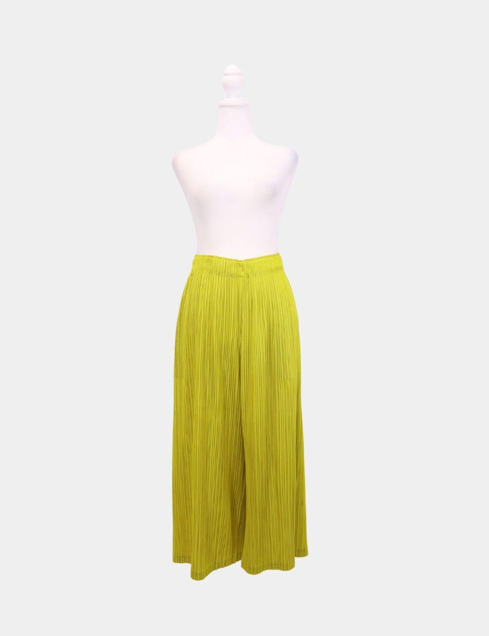 Effortlessly chic and unmistakably modern, these Pleats Please Issey Miyake wide-leg pants are a bold yet versatile addition to any wardrobe. Rendered in a vibrant chartreuse yellow, the signature pleated fabric offers lightweight structure, all-day