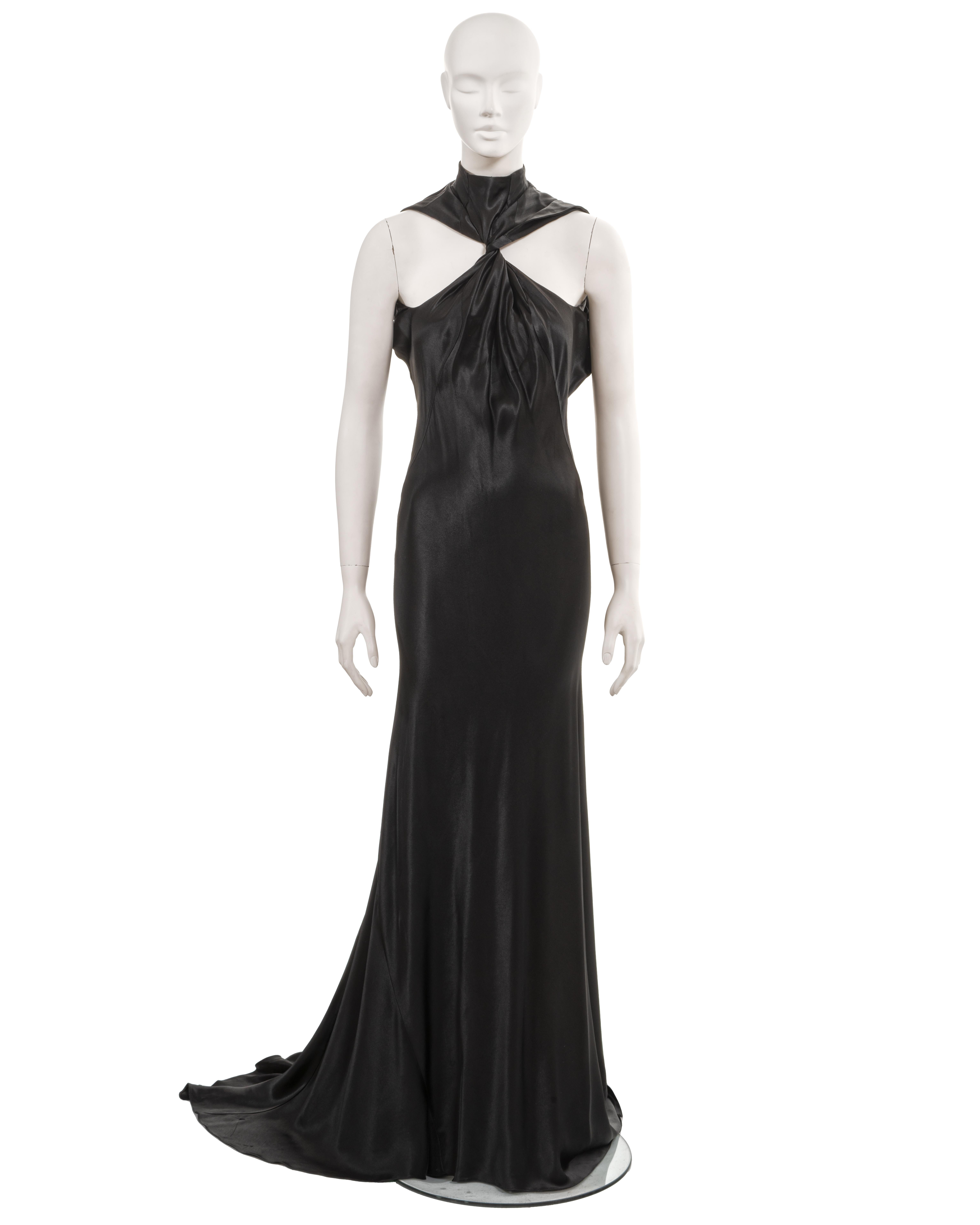 ▪ Plein Sud halterneck evening dress
▪ c. 1990
▪ Sold by One of a Kind Archive
▪ Black bias-cut satin 
▪ High neck with singular button fastening at the rear
▪ Twisted neckline and shoulder straps 
▪ Floor-length skirt with dramatic train 
▪ Size