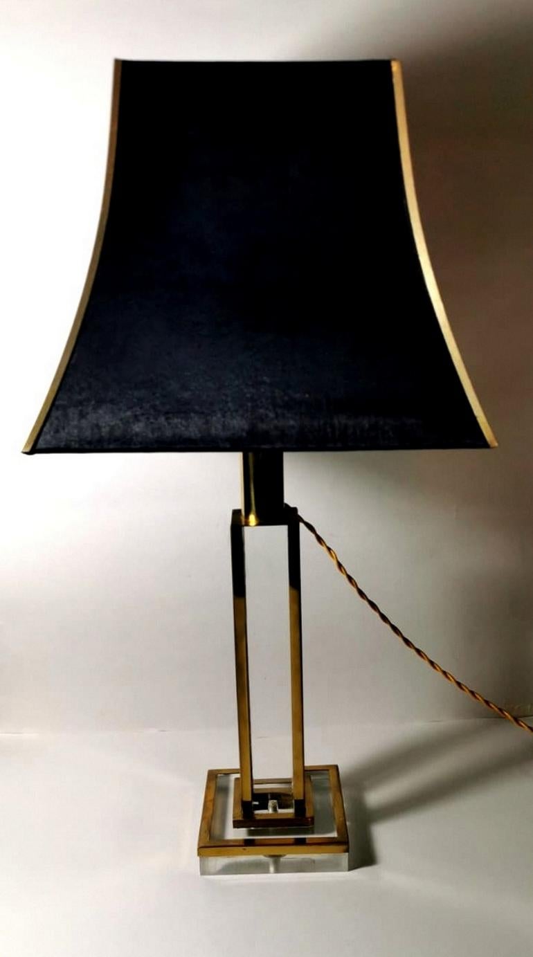 Original lamp produced in the 1970s, the central part is a rectangular block of plexiglass, on the corners have been applied brass corner bars; the square base has the same type of workmanship; the lampshade, in refined black satin, has a graceful