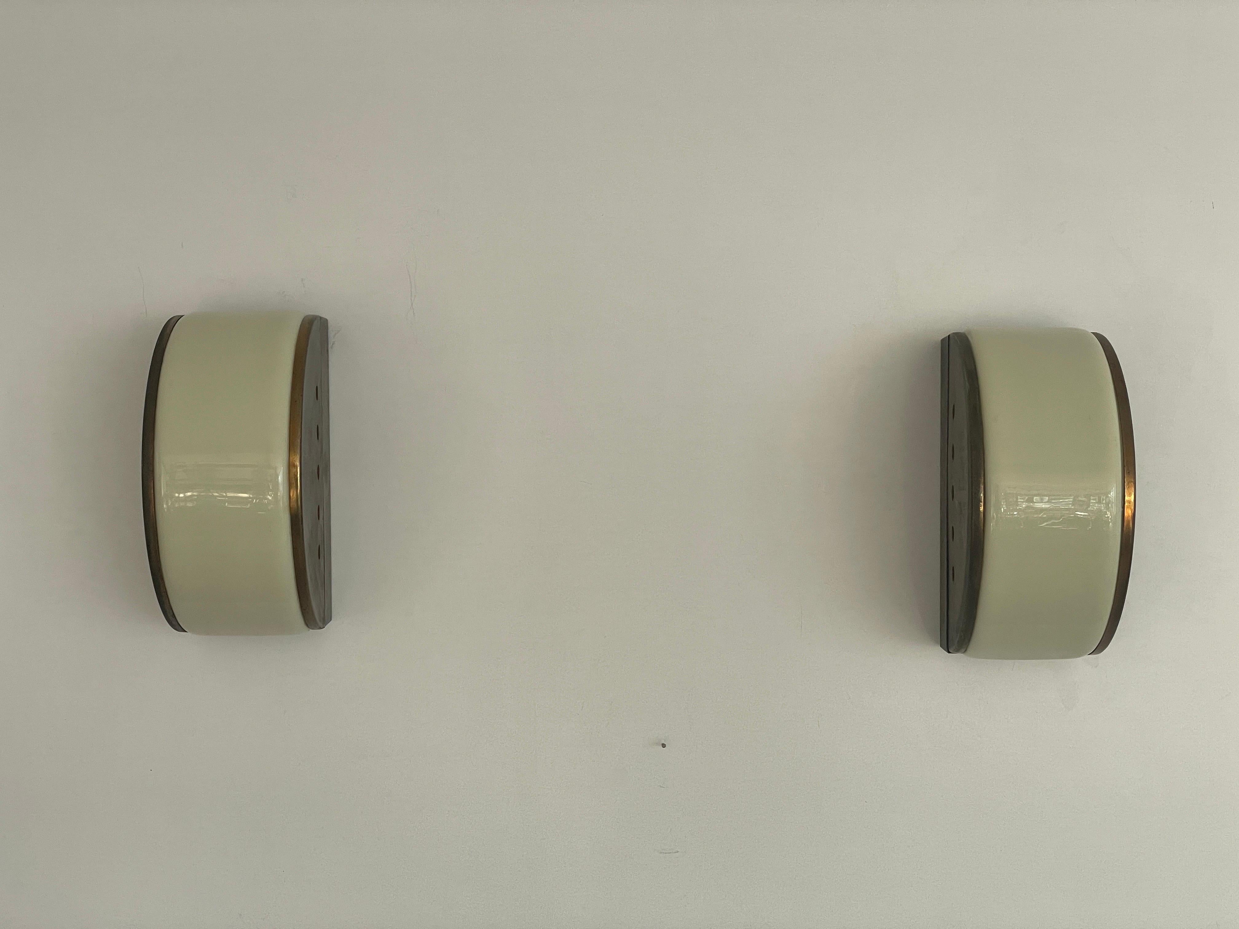 Paire d'appliques demi-lune en plexiglas et laiton, 1960, Italie

Appliques très élégantes et minimalistes
La lampe est en très bon état.

Ces lampes fonctionnent avec des ampoules standard E14. 
Câblé et utilisable dans tous les pays. (110-220