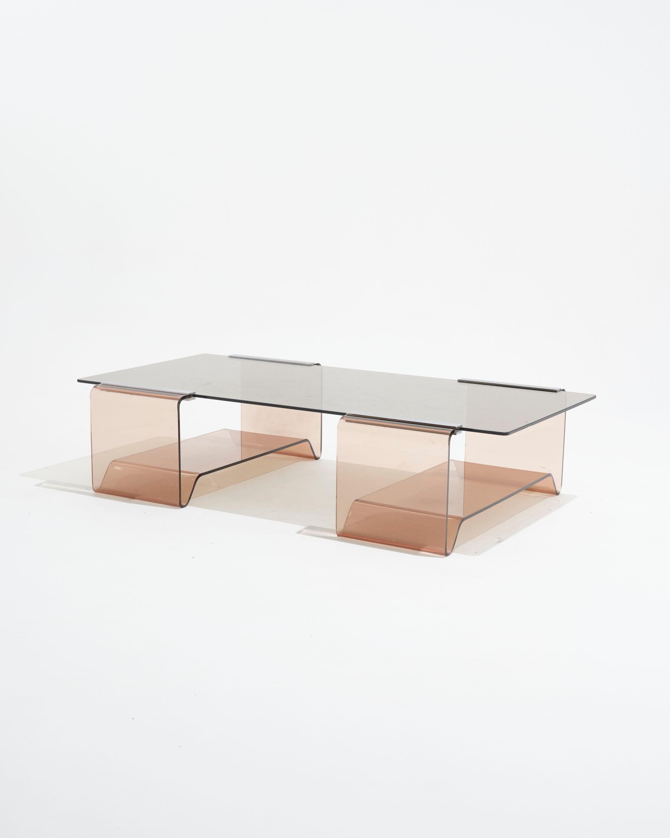 Tavolino in plexiglass e vetro di Michel Dumas per Roche Bobois, anni Settanta.
Struttura in plexiglass termoformato fumé con dettagli cromati e piano in vetro fumé. Sulla superficie sono visibili graffi e segni di utilizzo.

LP5595