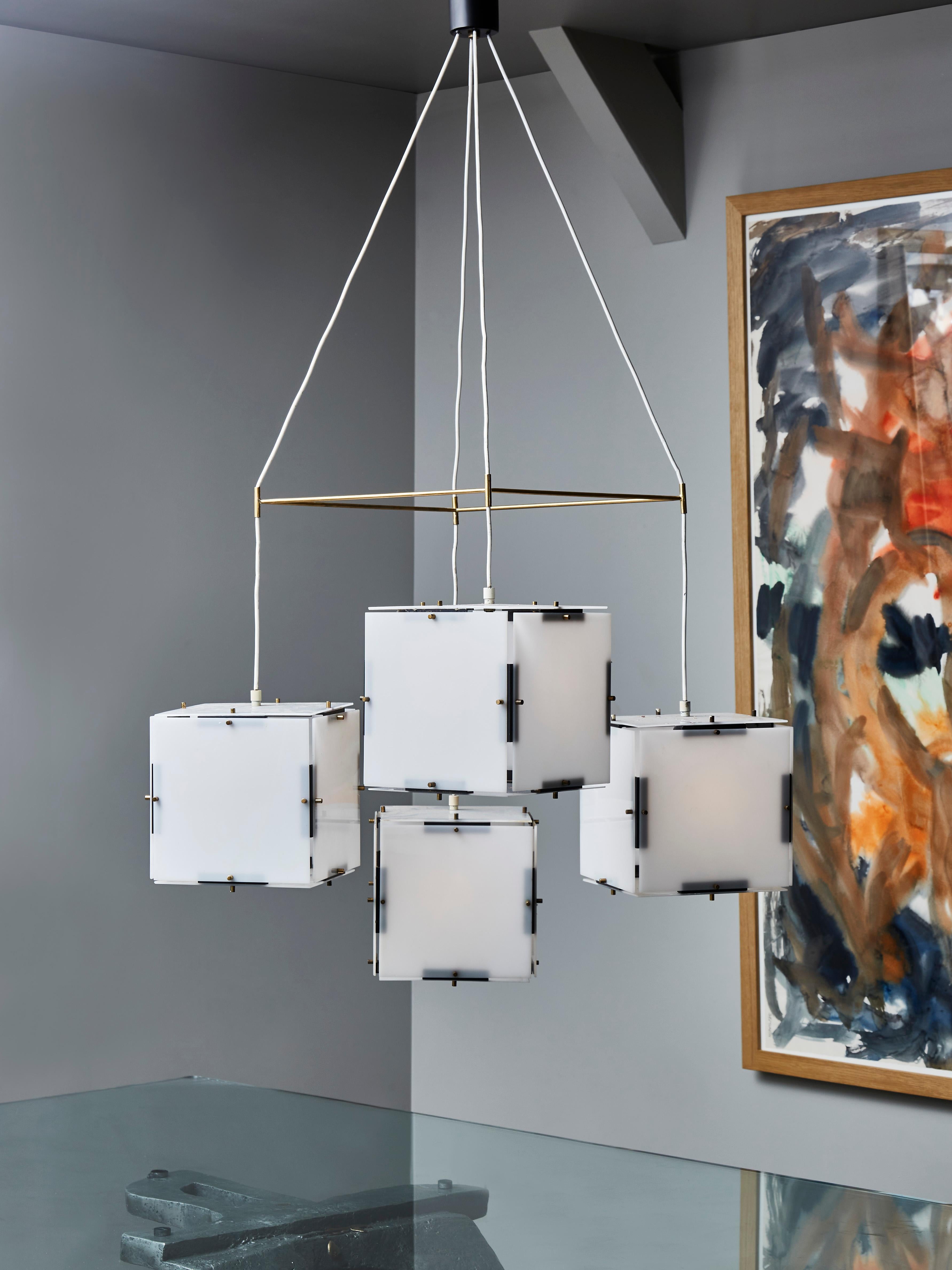 Nice chandelier made by Stilux Milano in the 1960s.

The chandelier is made of four cubes each composed of plexi sheets held by brass pins and metal setting.

The four elements are spread apart by a brass square in which each cable thread