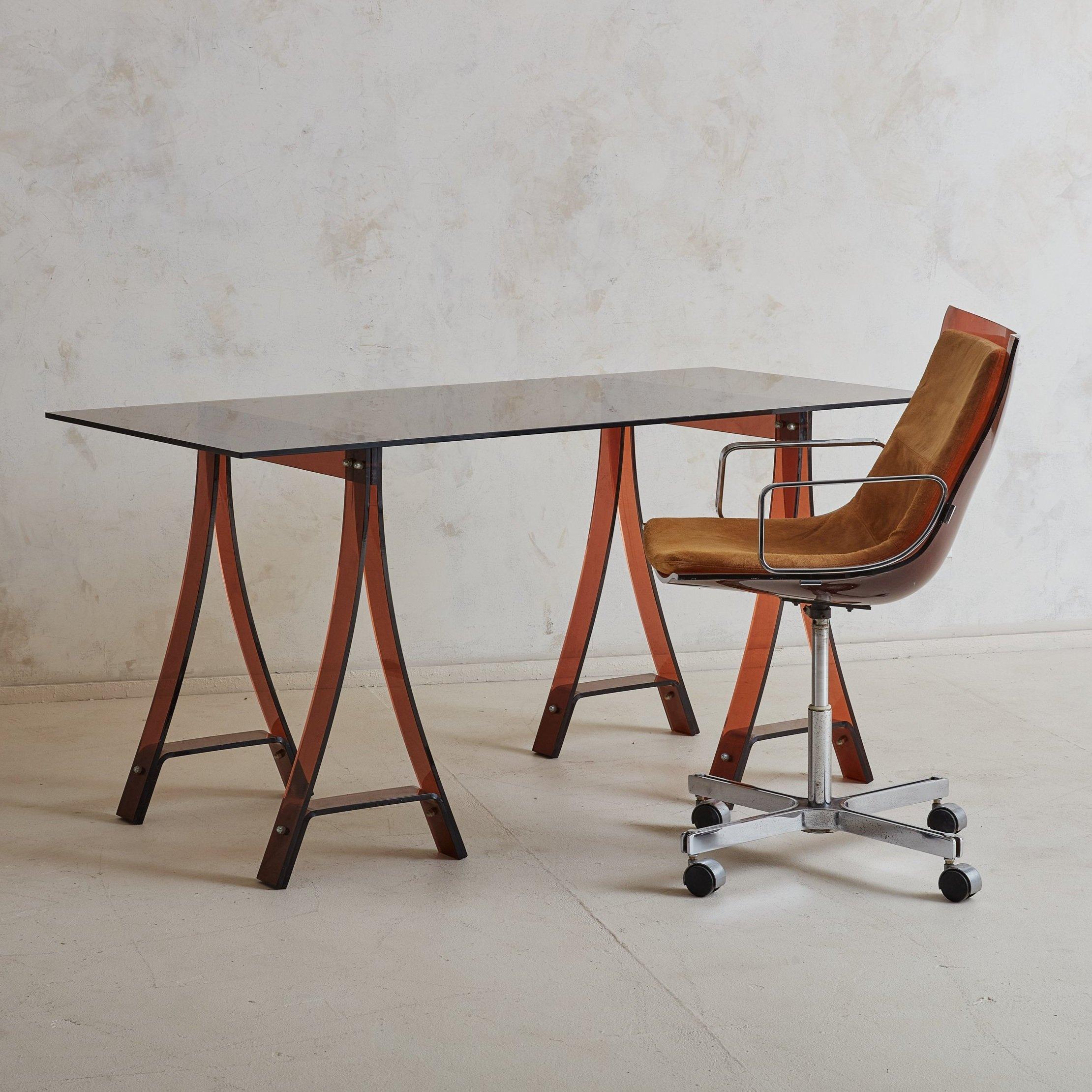 A gorgeous French desk or work table designed by Marcello Gacita + Pierre Tiberi in the 1970s. This piece features two amber plexiglass trestle legs with circular chrome hardware and a rectangular smoked glass top. Styled here with our Plexiglass
