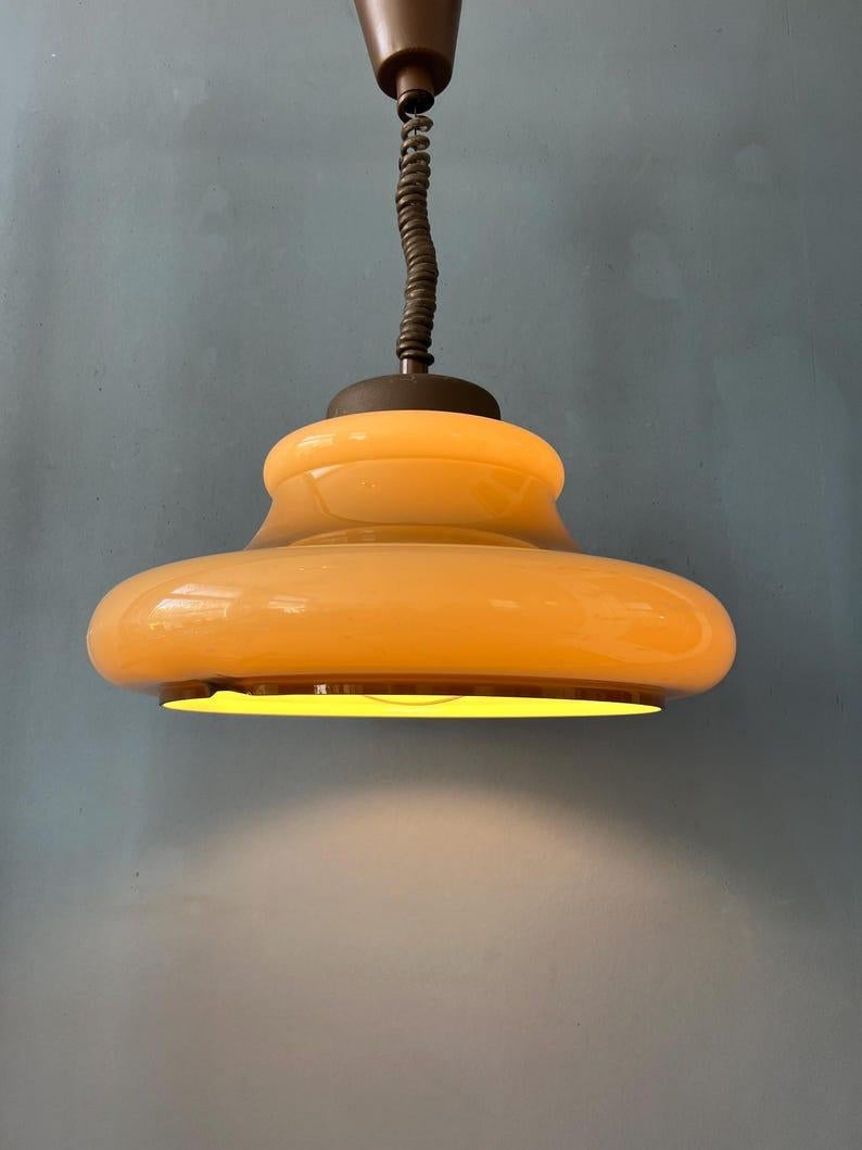 Lampada a sospensione Herda in plexiglass beige. L'altezza della lampada può essere regolata con il sistema di salita e discesa. La lampada richiede una lampadina E26/27.

Informazioni aggiuntive:
Materiali: Metallo, plastica
Periodo:
