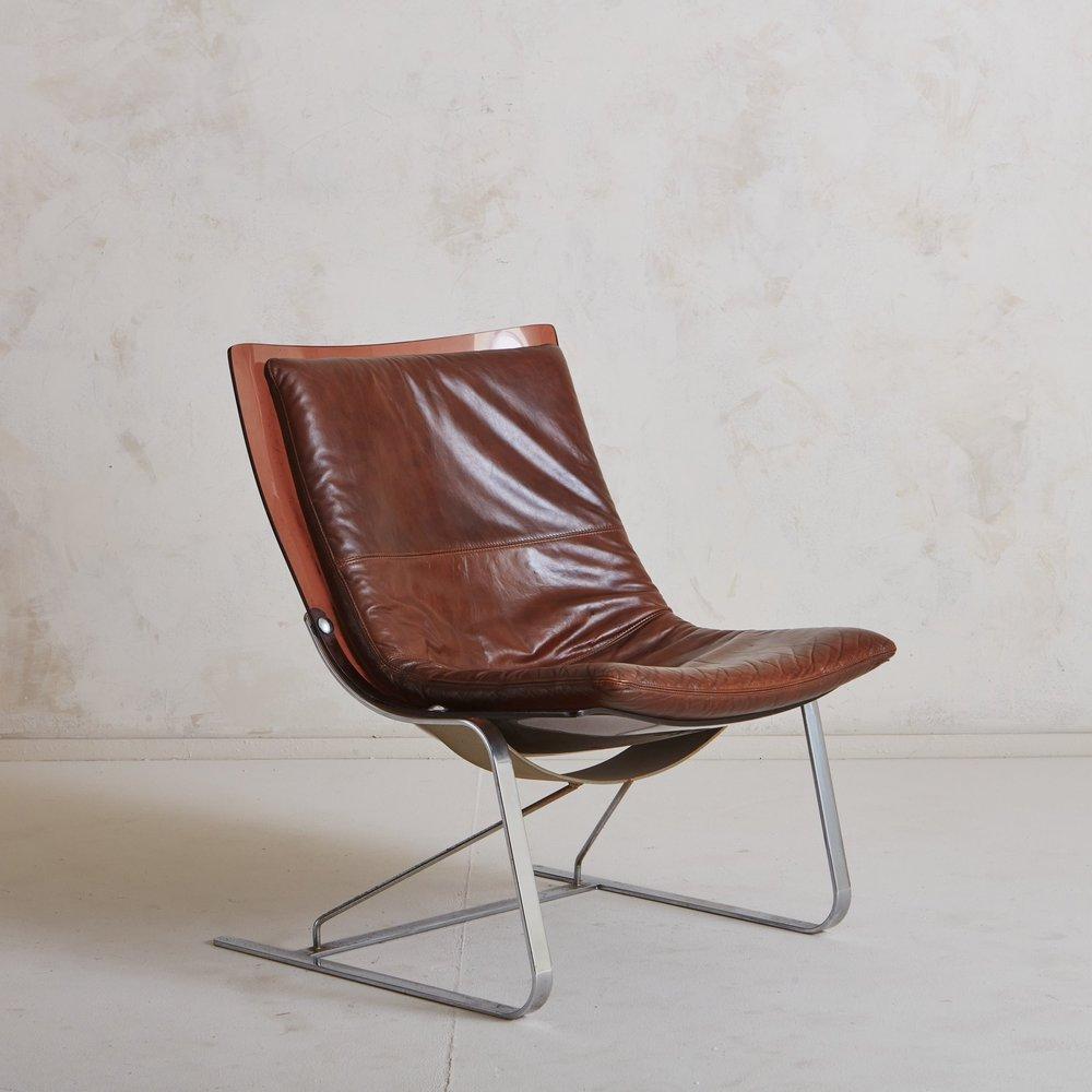A vintage Italian lounge chair featuring a curved amber plexiglass frame which sits on a cantilevered chrome base with two tubular support bars. It has a removable patinated leather cushion with stitch detailing. Sourced in Italy, 20th century.