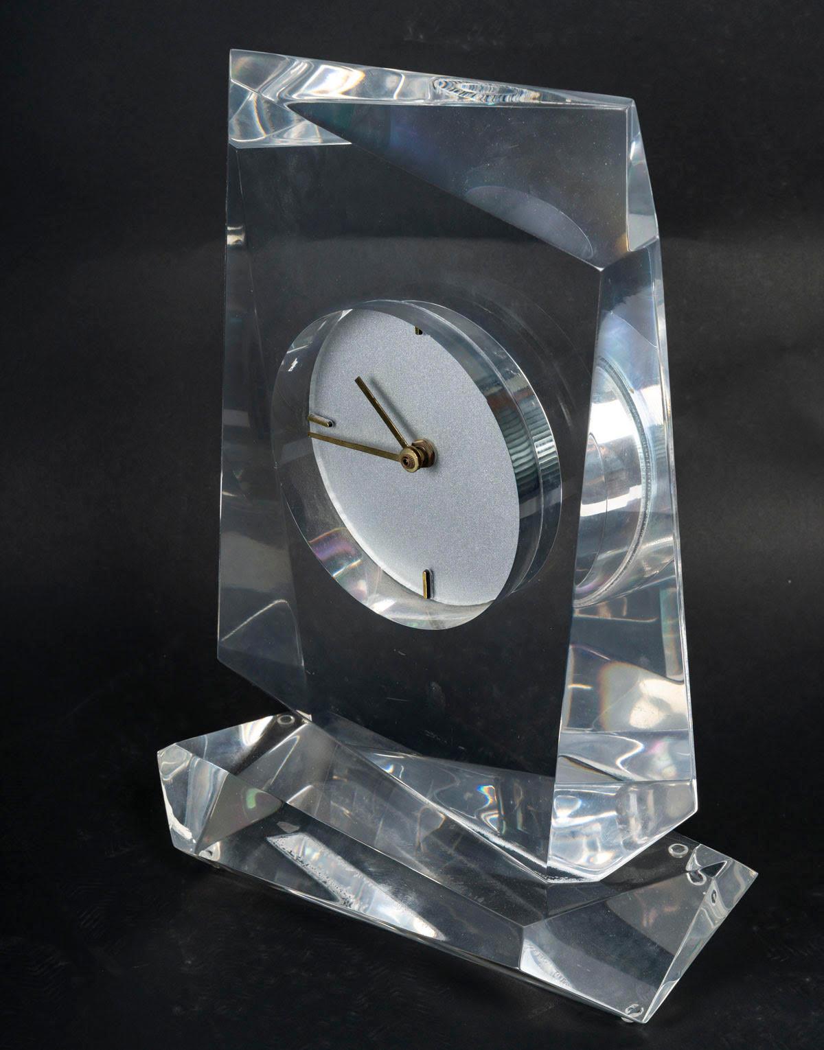 Plexiglass table clock, 1970s design.

1970s table clock, contemporary design, plexiglass.
H: 35cm. W: 25cm, D: 13cm