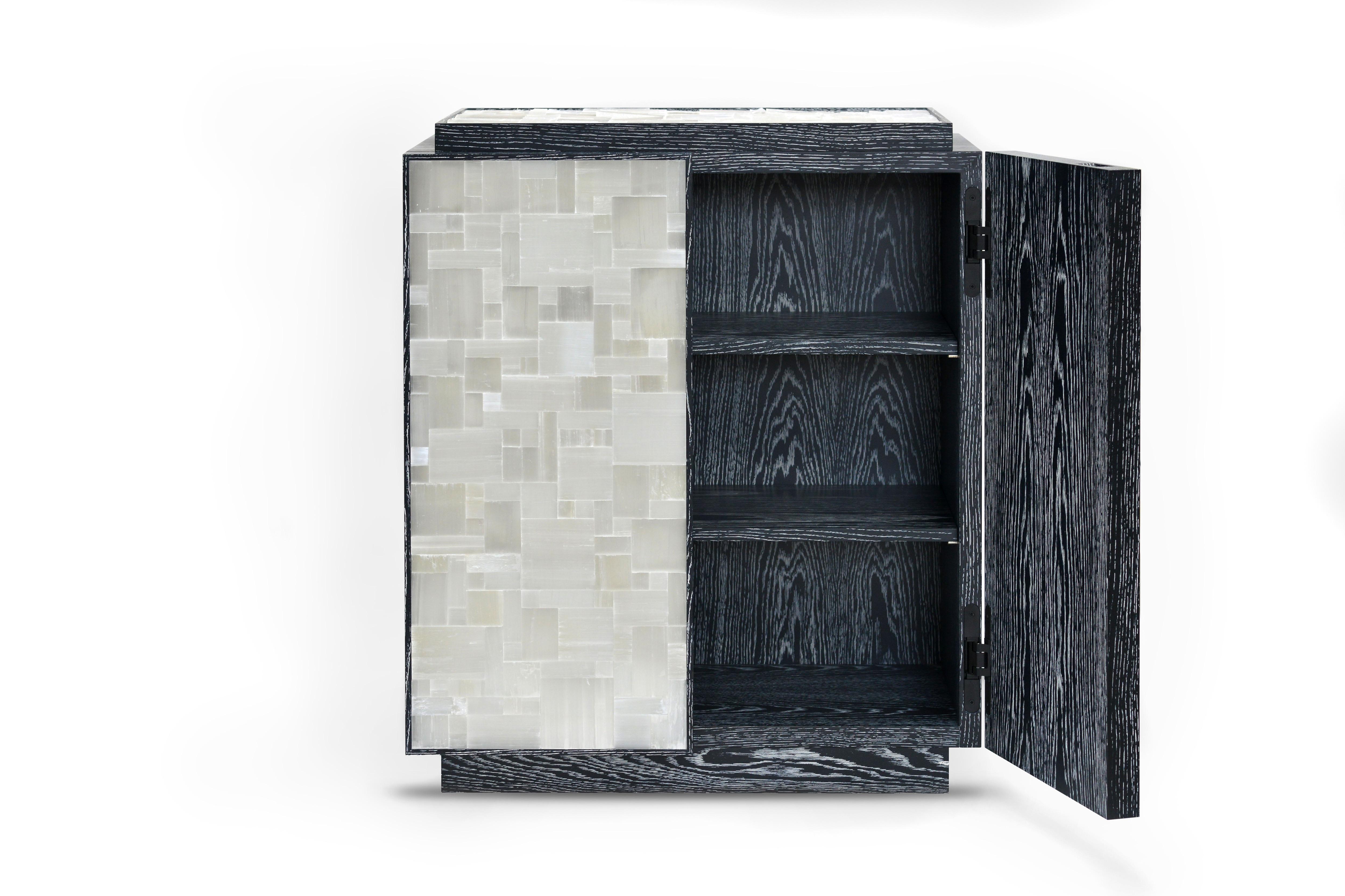 Designed by Simon Stewart for Masterpiece 2019, the Plexus cabinet combines black cerused with tessellated selenite inlaid into the doors and top. 

Simply finished internally with two cerused oak shelves. The doors have an integrated finger
