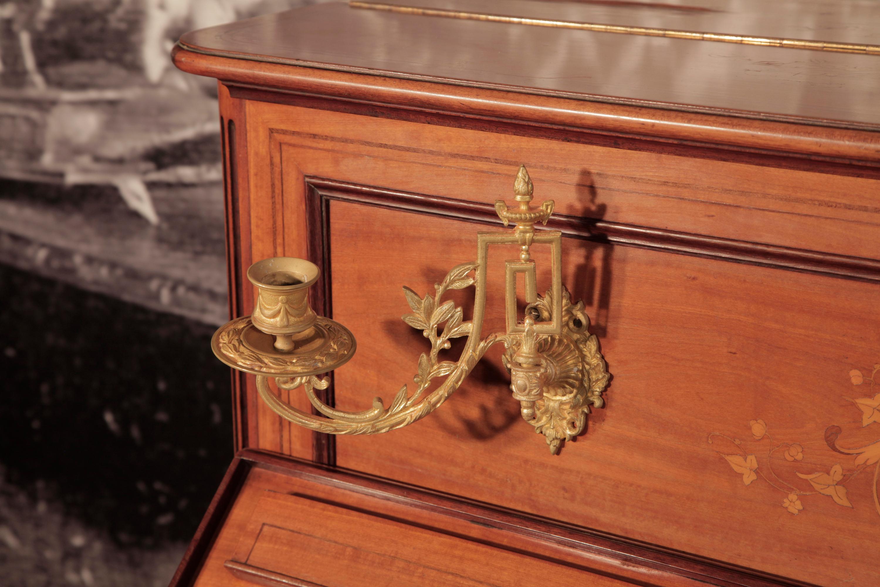 Ein Pleyel-Klavier aus dem Jahr 1893 mit einem Gehäuse aus satiniertem Holz.
Das gesamte Gehäuse ist mit komplizierten Intarsien im neoklassischen Stil versehen. Die Frontpaneele weisen ein symmetrisches Muster aus Akanthusranken, Blumen,
