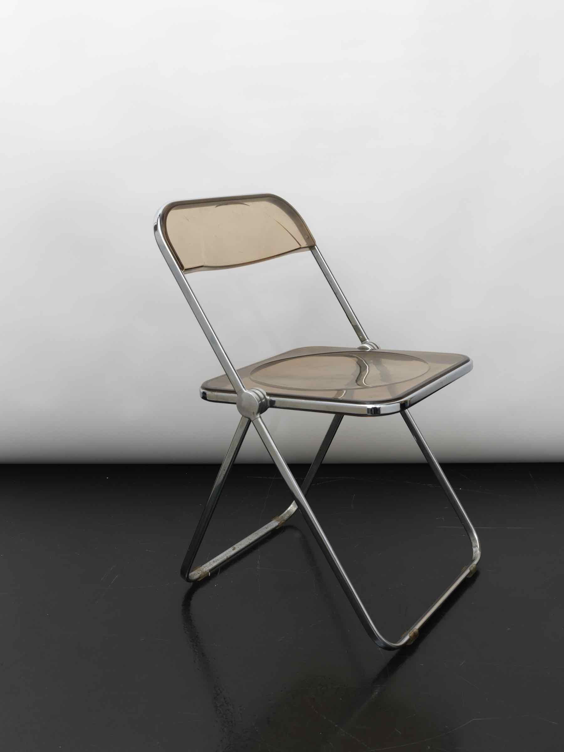 Plia chair with smoked brown transparent plexi glass, 1980s.
Designed by Giancarlo Piretti for Castelli in 1967.

It's an award-winning design classic.
With the Plia folding chair Giancarlo Piretti made design history.

It's development of the 3