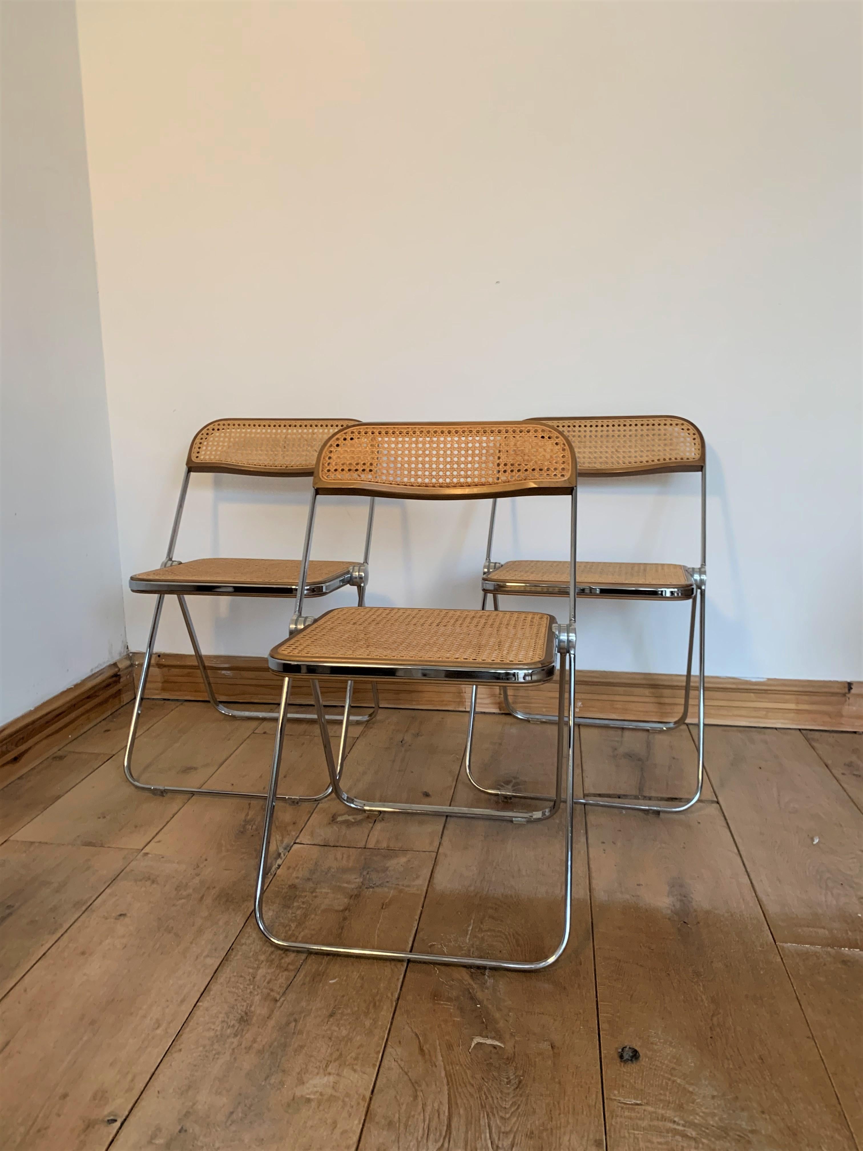 Original vintage Plia chairs designed by Giancarlo Piretti for Castelli in 1967. These folding chairs are made of rattan and chrome or wood frame. They are used with signs of wear due to age but still in very good condition. The Plia folding chair