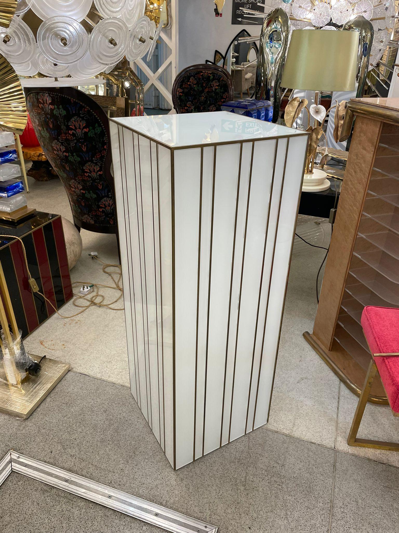 Elegant white colour Glass Plinth decorated with brass fixtures. It is an elegant touch in any room to display this beautiful piece of art. Italy, 1980s.