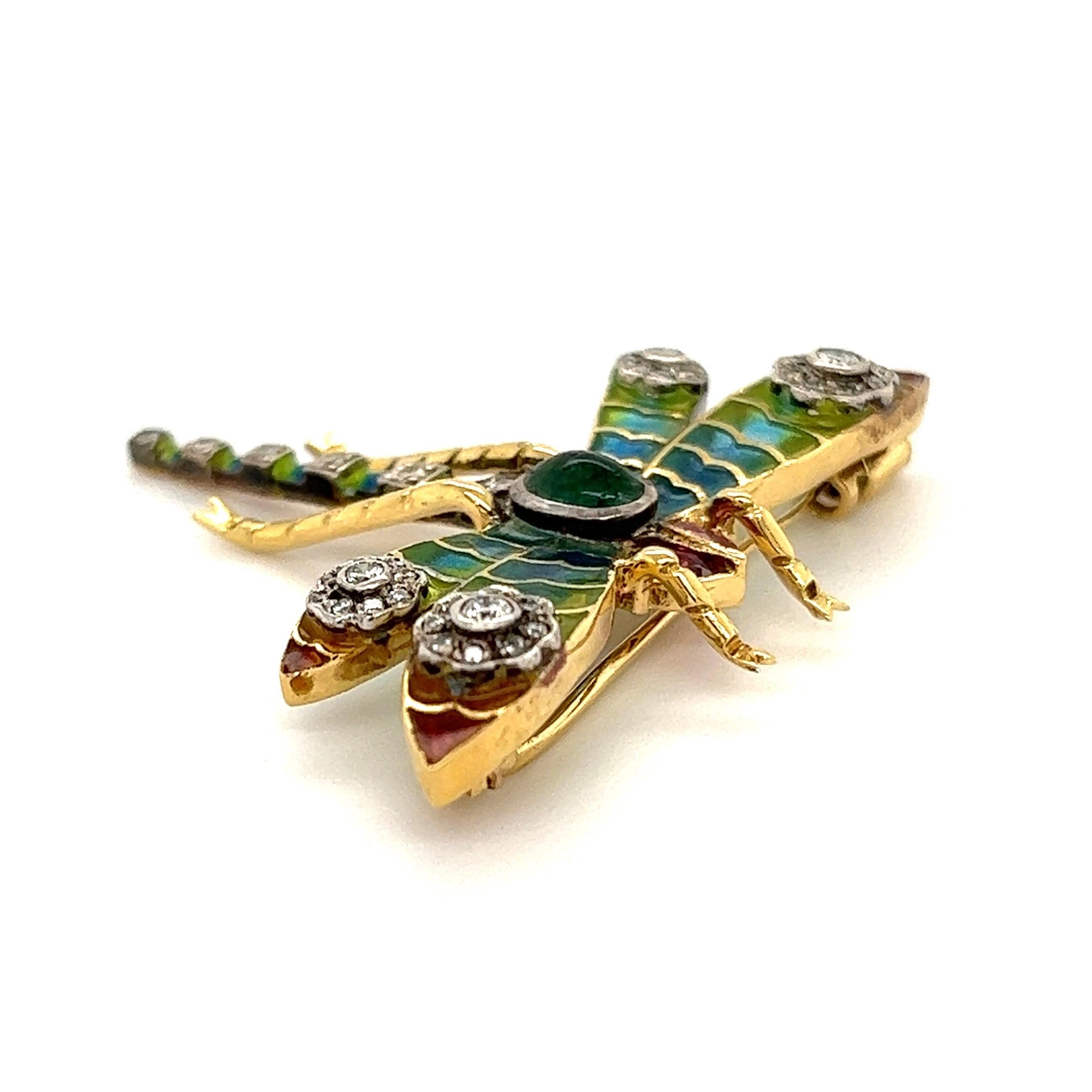 Simply Beautiful! Plique-à-Jour Dragonfly Brooch with Blue, Green and Red Enamel Wings, Hand set with Rubies, approx. 0.30tcw, Emeralds 0.25ct and Diamonds, approx. 0.32tcw. Hand crafted in 18 Karat Yellow Gold. Approx. size: 1.75” tall. This pin is