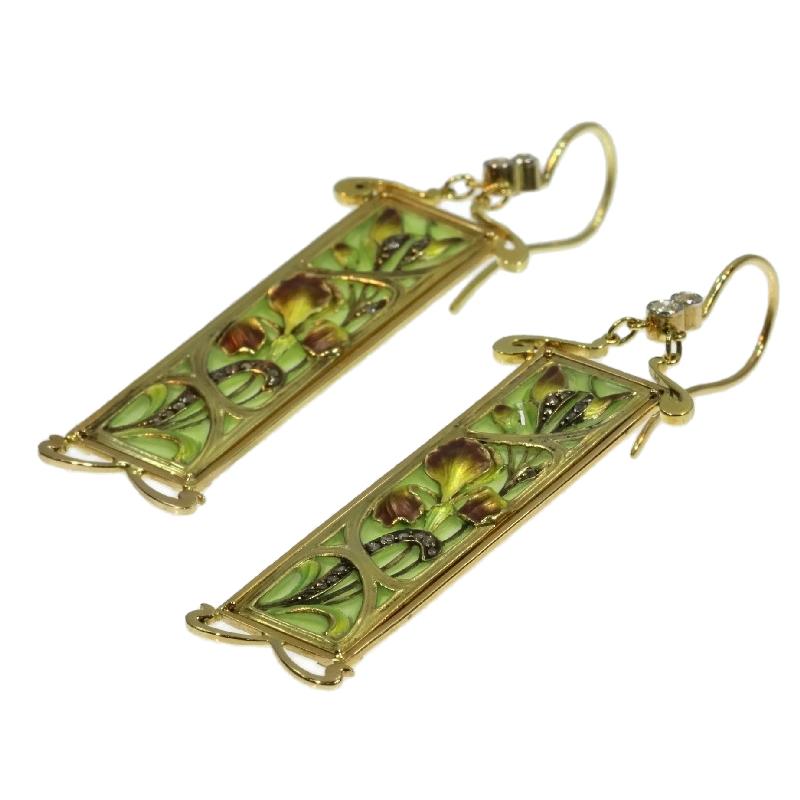 Within these picturesque Art Nouveau earrings crafted in 18K yellow gold and plique-à-jour enamel, a fleeting daydream of an iris meadow glistening of old mine brilliant cut and rose cut diamonds is captured by a glance through a windowpane. Almost