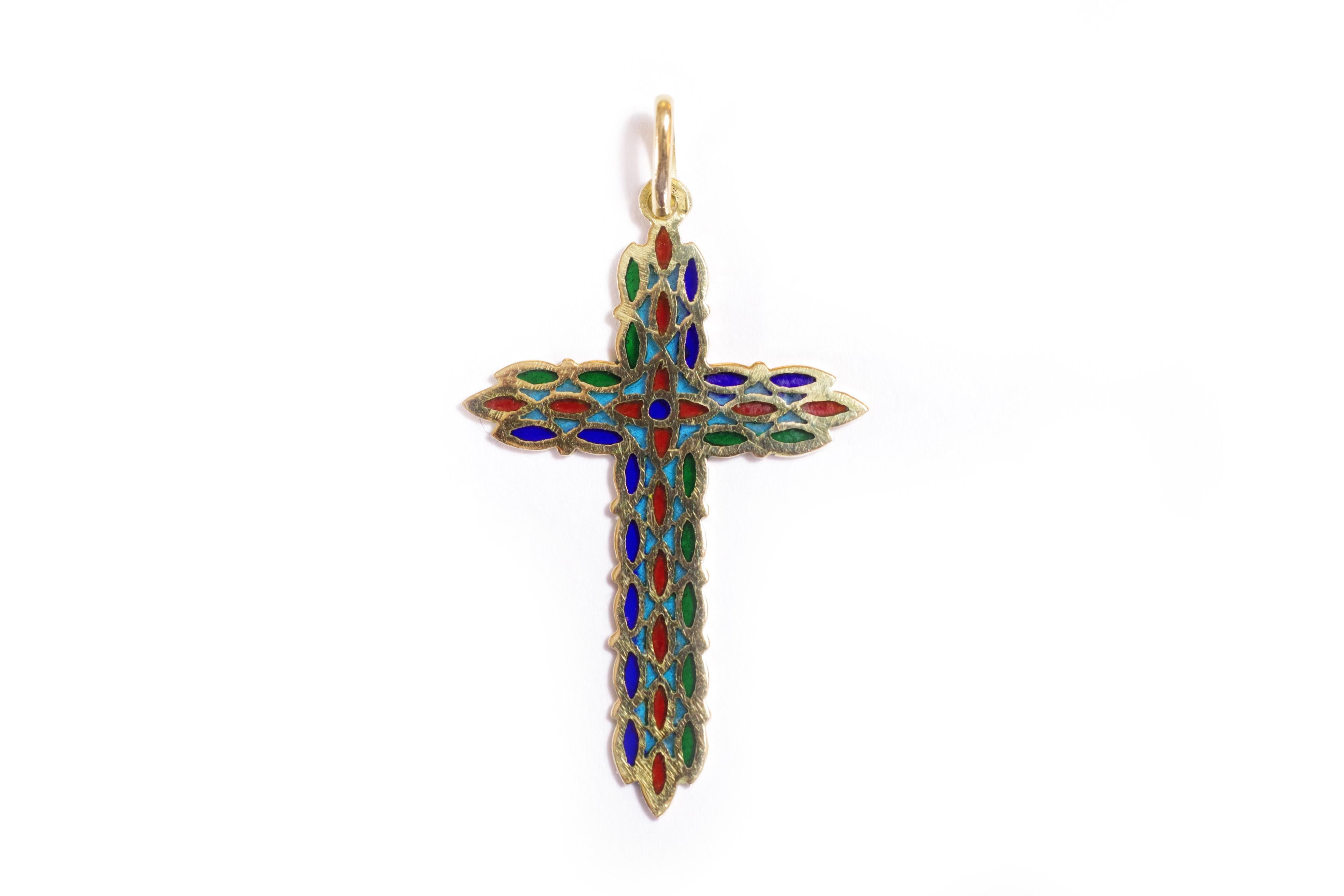 Plique a jour enamel cross pendant in 18 karat yellow gold. This religious pendant is elegantly decorated with translucent enamels of blue, green and red, reminiscent of church windows. Enamel is a technique consisting of melting minerals reduced to