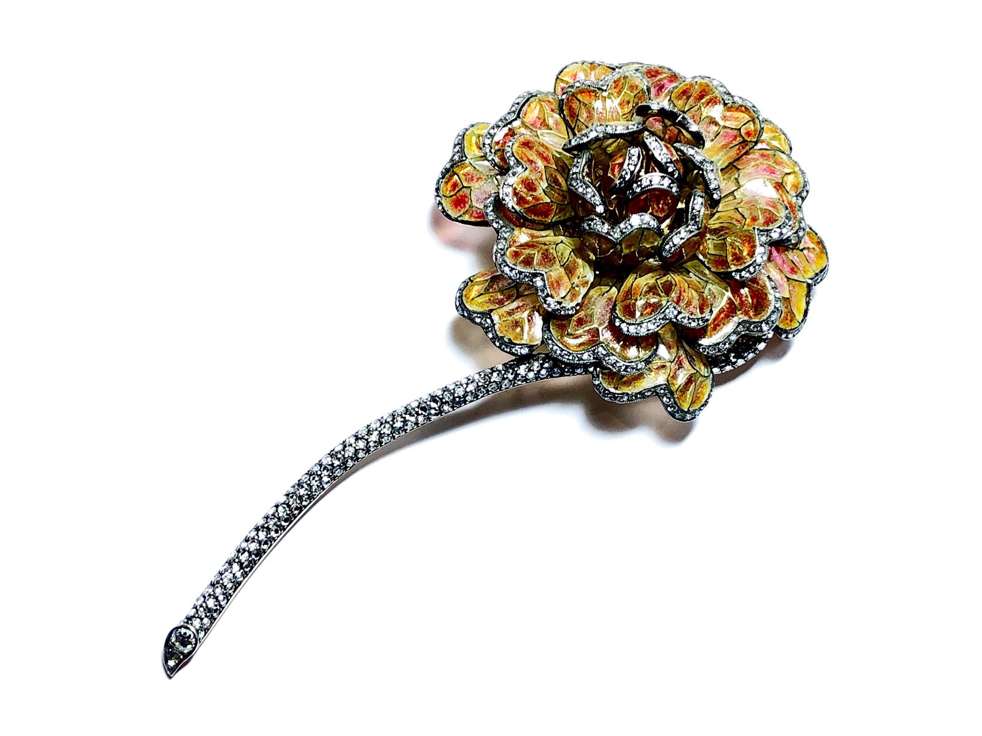 A Moira Design enamel and diamond chrysanthemum brooch, brown to orange plique á jour enamel petals, with single cut diamonds set on the outer edge of each petal and to the full stem, mounted in 18ct yellow gold, signed Moira, numbered 6234