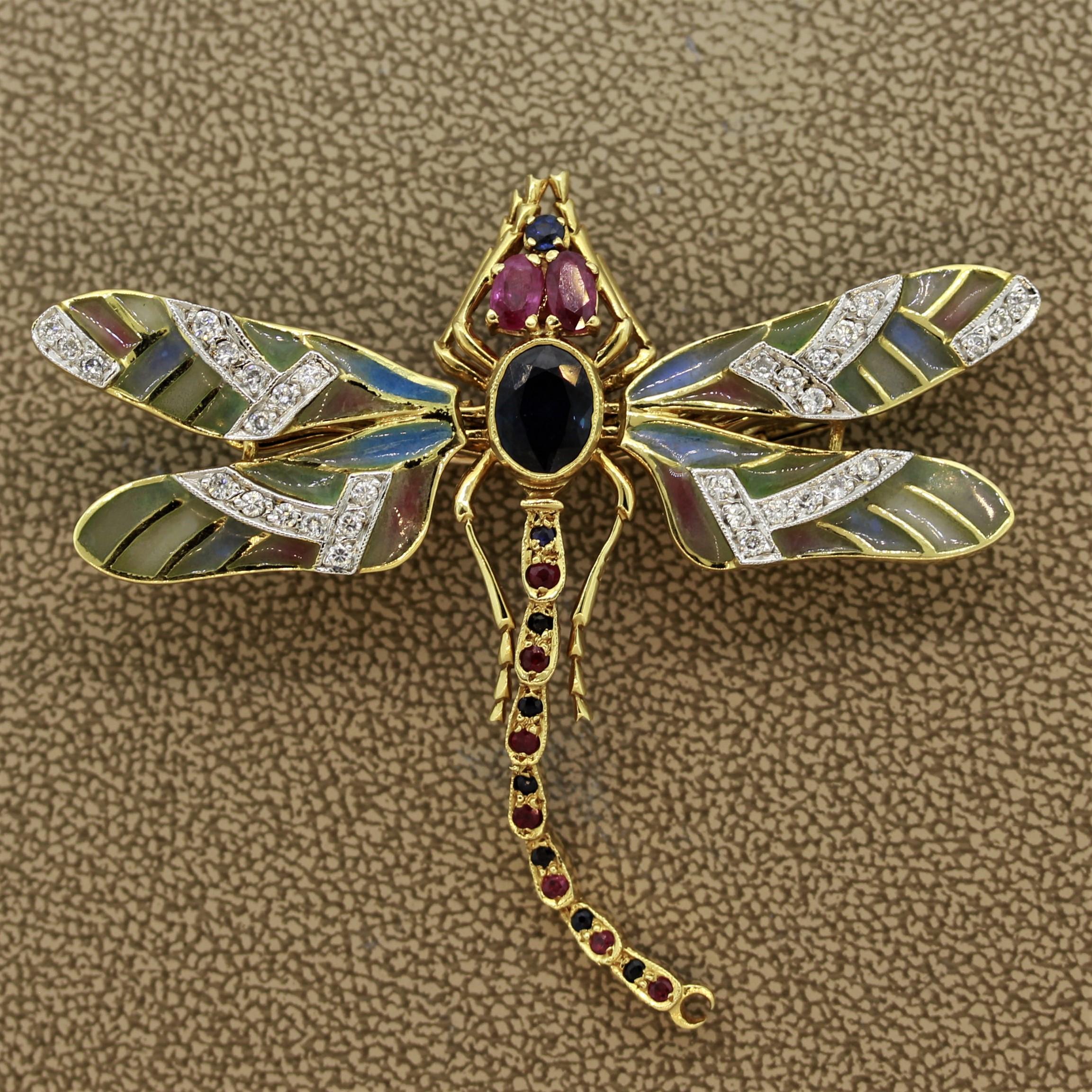 A unique dragonfly brooch. It features enameled Plique-a-Jour wings, which are enamel without a backing making a “window” allowing light to pass. Adding to that are round brilliant cut diamonds set on the wings. Sapphires and rubies decorate and