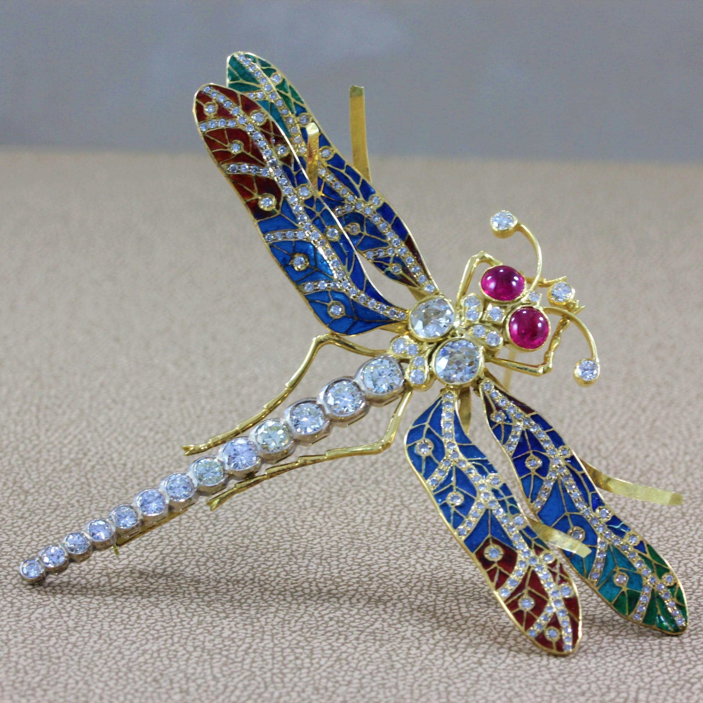 A magnificent example of fine quality plique-a-jour by an experienced master jeweler. Approximately 5 carats of diamond and 1.50 carats of ruby accent the intricately designed brooch. The wings of the dragonfly are filled with vivid red, green and