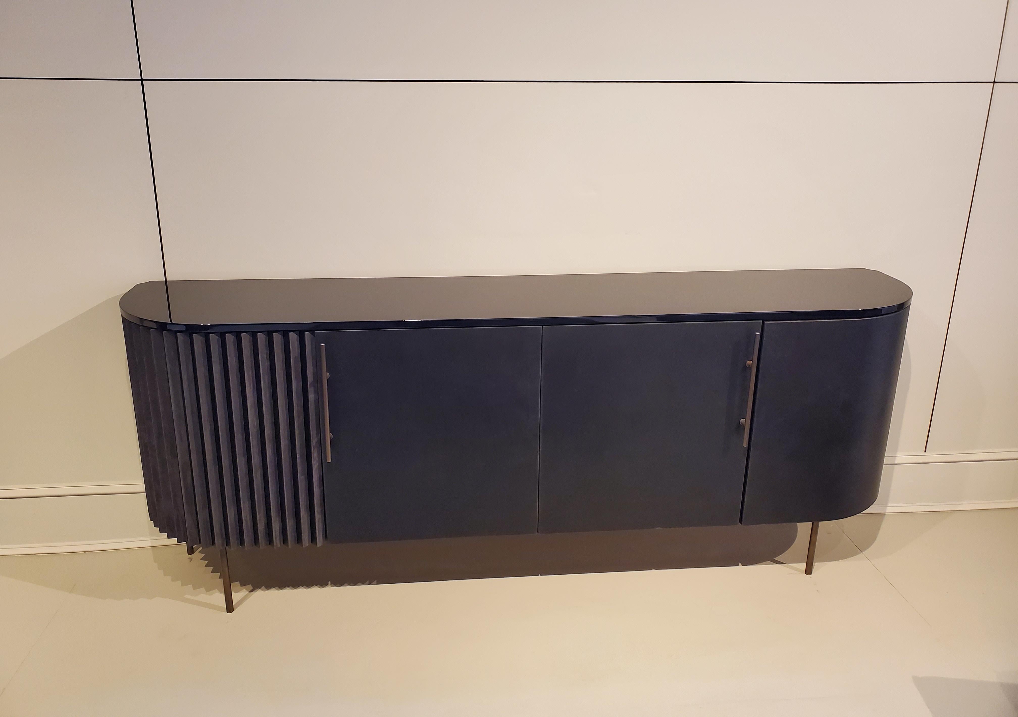 Made in Italy.

An elegant, grounding credenza with a delightful corner twist, offering a captivating view into its pleated detail at every angle. Designed by Draga & Aurel.

Showroom floor model in great condition. 

Burnished brass base.