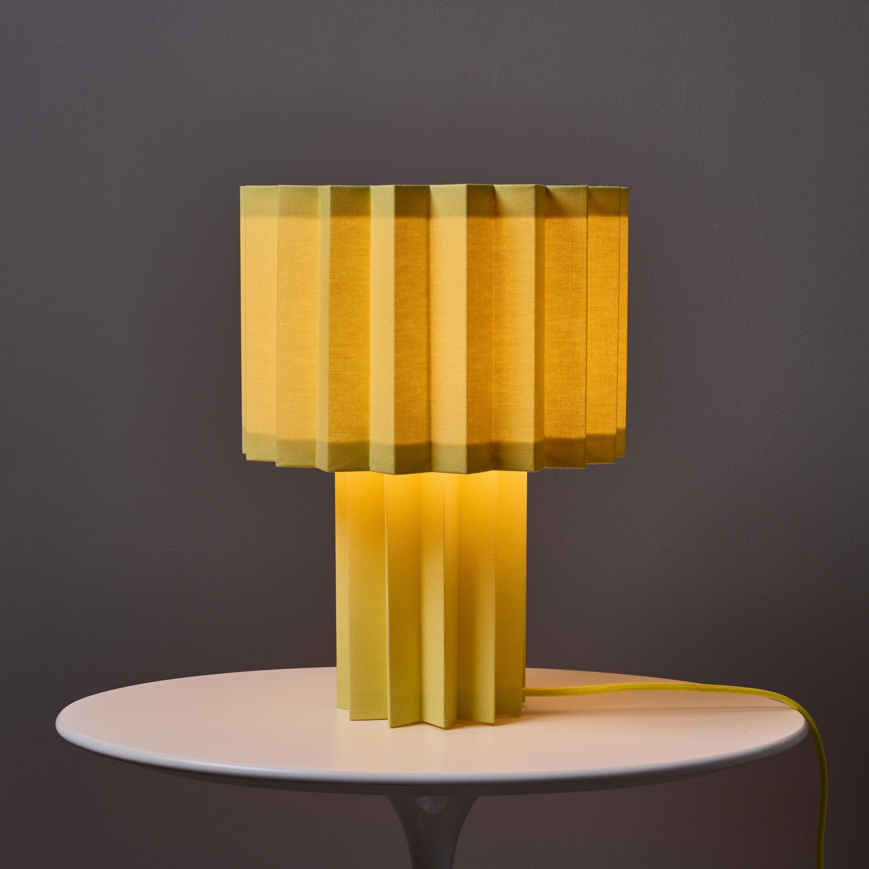 Lámpara de mesa textil plisada 'Plissé Yellow Edition' de Folkform para Örsjö.

Novedad para 2025, esta edición amarilla de la Plissé aporta un estallido de color y geometría a cualquier espacio. Esta singular lámpara de sobremesa fue galardonada