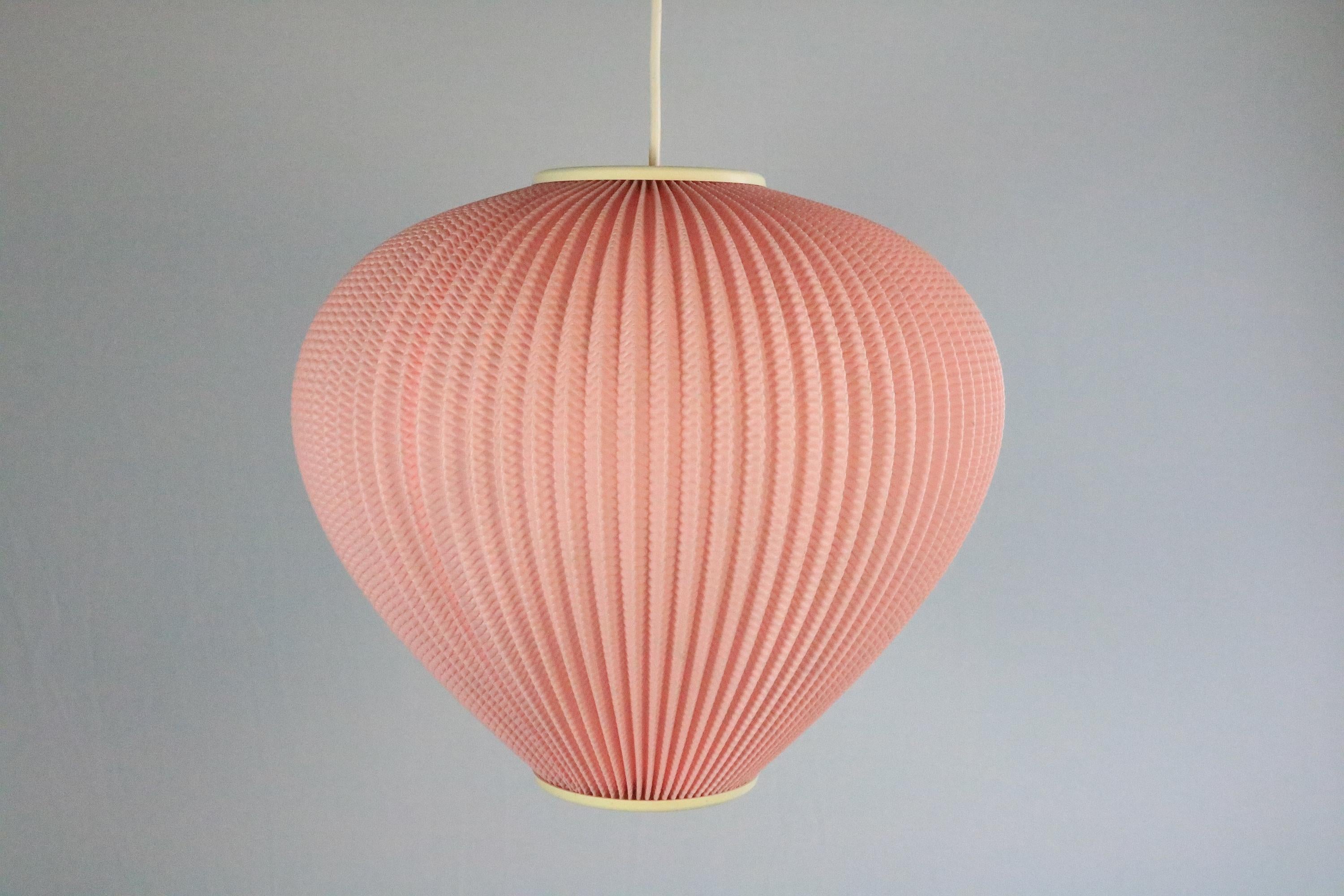 Charming pink hanging lamp in a beautiful shape.
Plissee plastic shade.
 
In good condition with minimal creases that are only visible when viewed from above. Seam visible when lit )see last photo).
 
Cable length as requested. High-quality textile