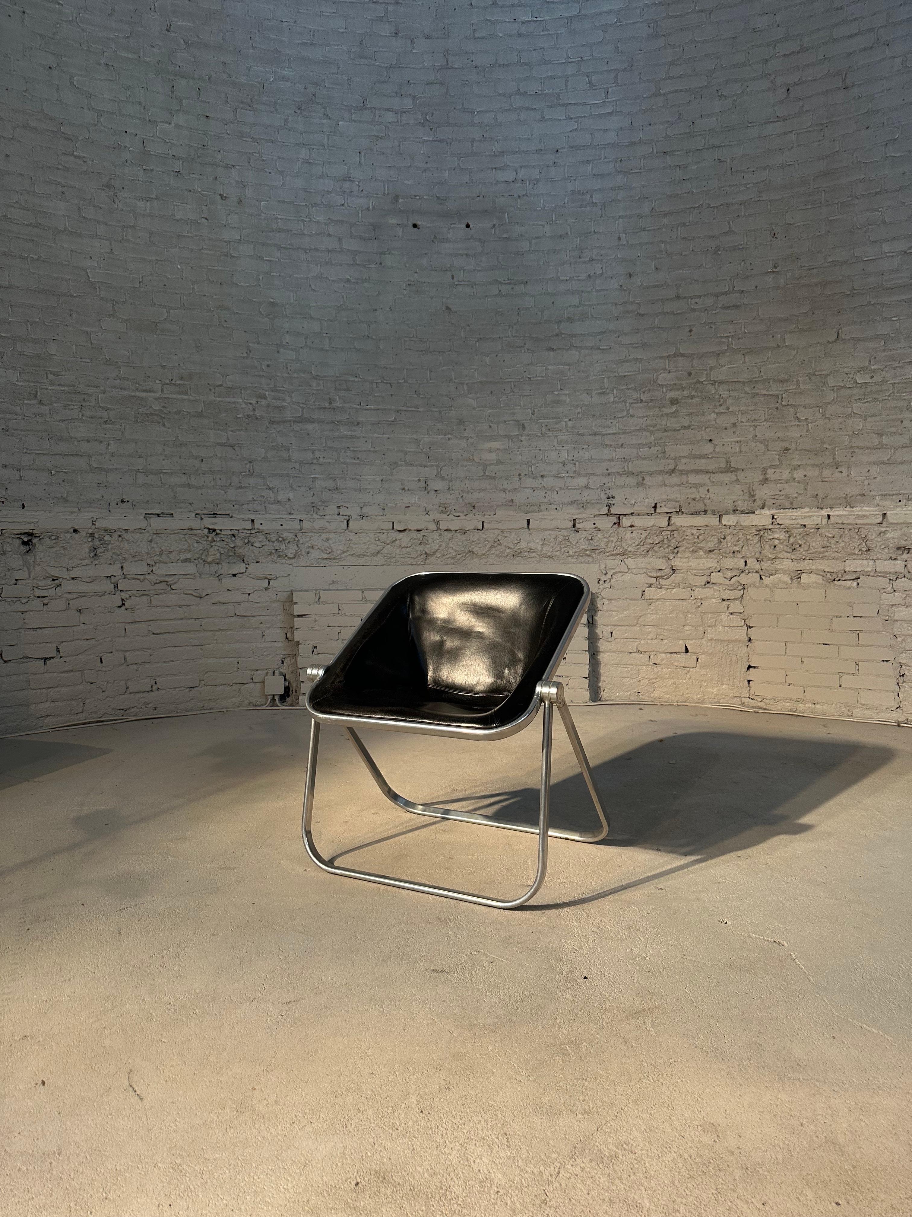 Designed in 1970 by Giancarlo Piretti, Plona is a folding and stackable armchair. Thanks to its unique design it combines aesthetics, functionality and comfort. The solid tubular structure is in a polished stainless aluminum alloy, with hinges in