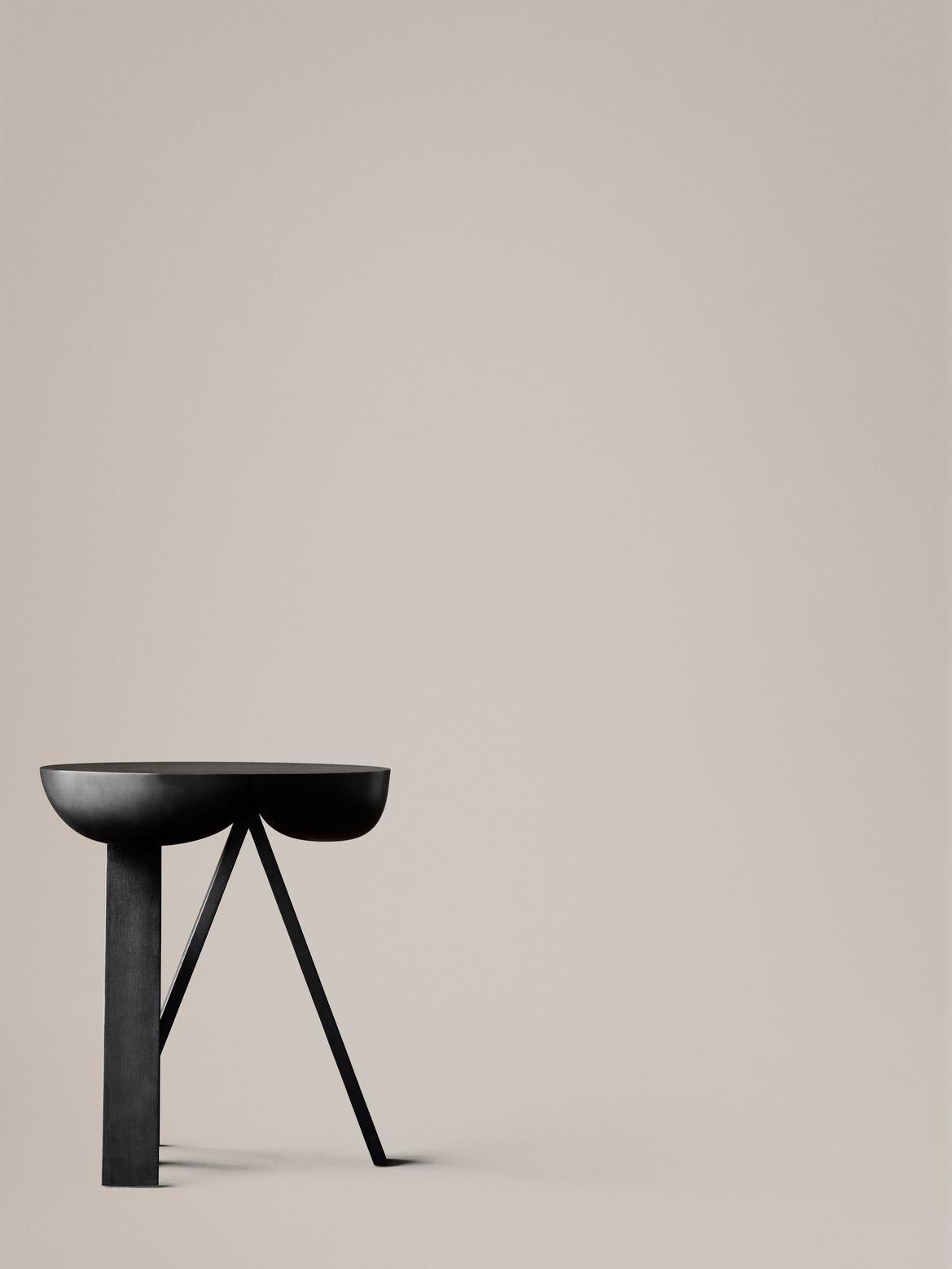 Side table designed by PlueerSmitt in 2014. 

Striking. Wooden side table consisting of two stripped-down trestles and a table top. The seemingly heavy top contrasts the rigid trestles. The top gives in and provides space for the sharp ends of the