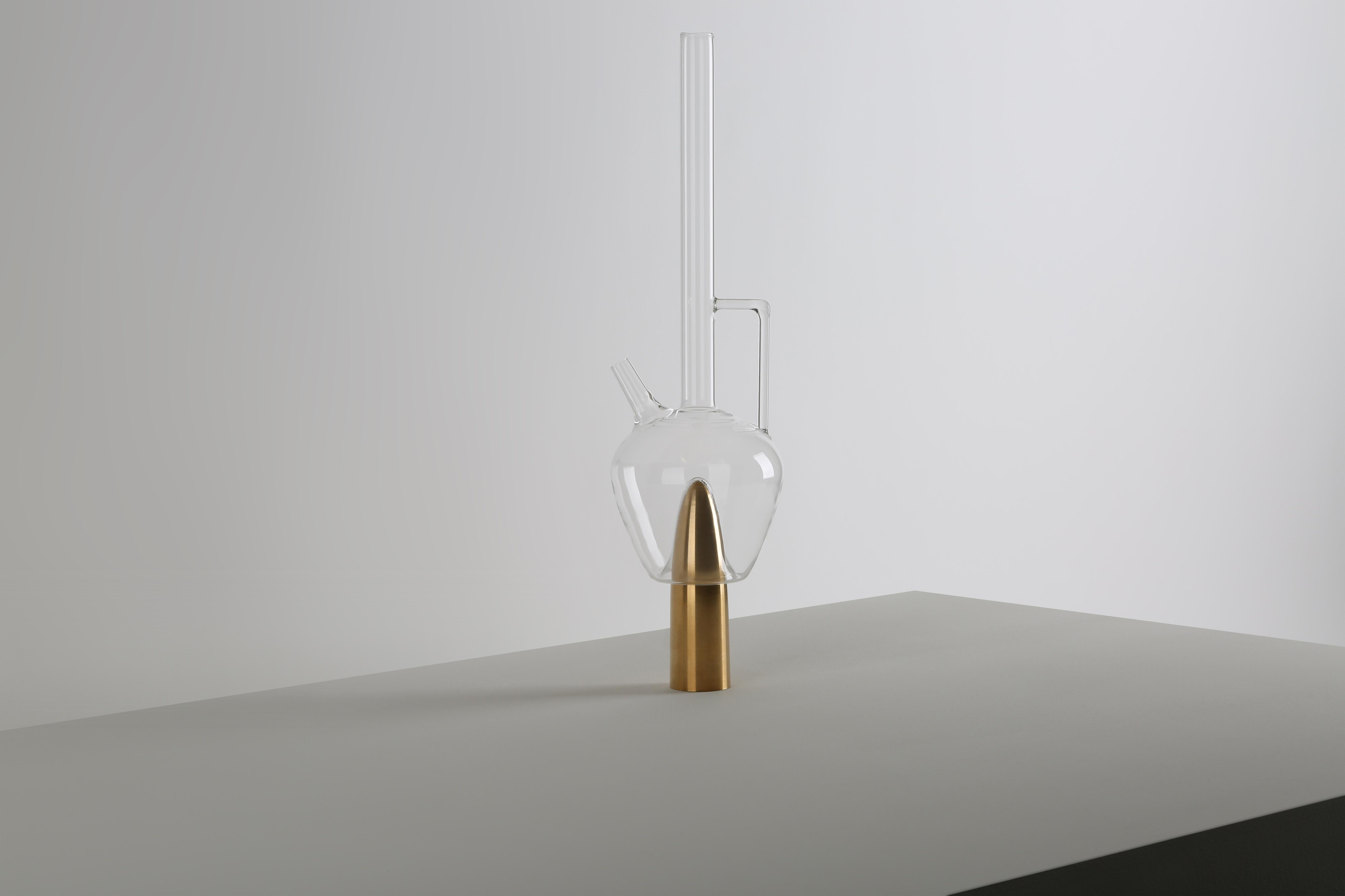 Plugged Carrafe by Richard Yasmine
Materials: hand-blown borosilicate glass with solid brushed brass base
Dimensions: 180cm x 48cm x 38cm

Made of solid brushed brass and a very thin hand-blown borosilicate glass mixed together to form one