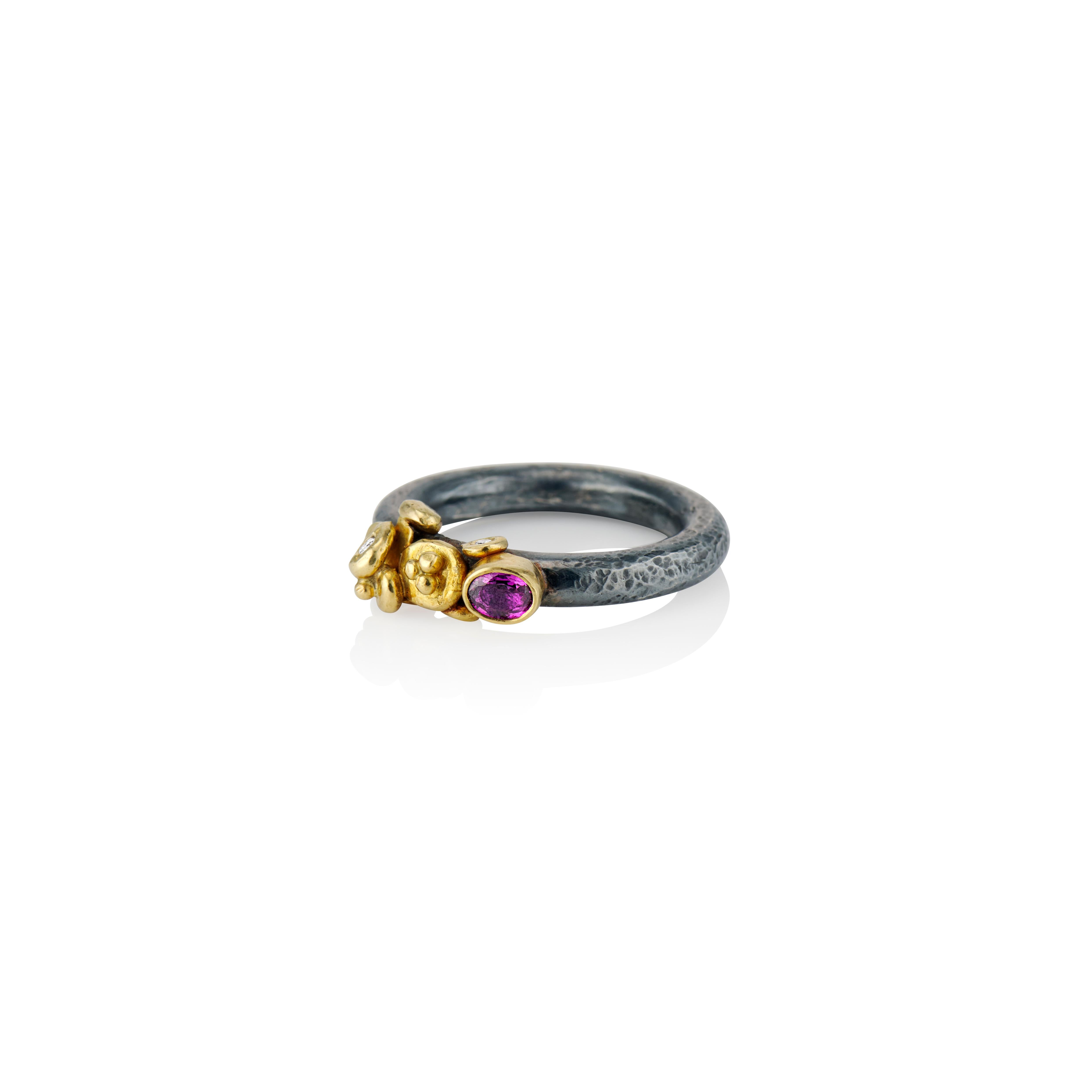 This charming ring tells its story in 22 karat yellow gold shards, granulation, diamonds and a .25 carat sapphire in a rich plum.  The ring shank is sterling silver patinated a dark gray adding contrast and mystery to this one of a kind ring.  It is