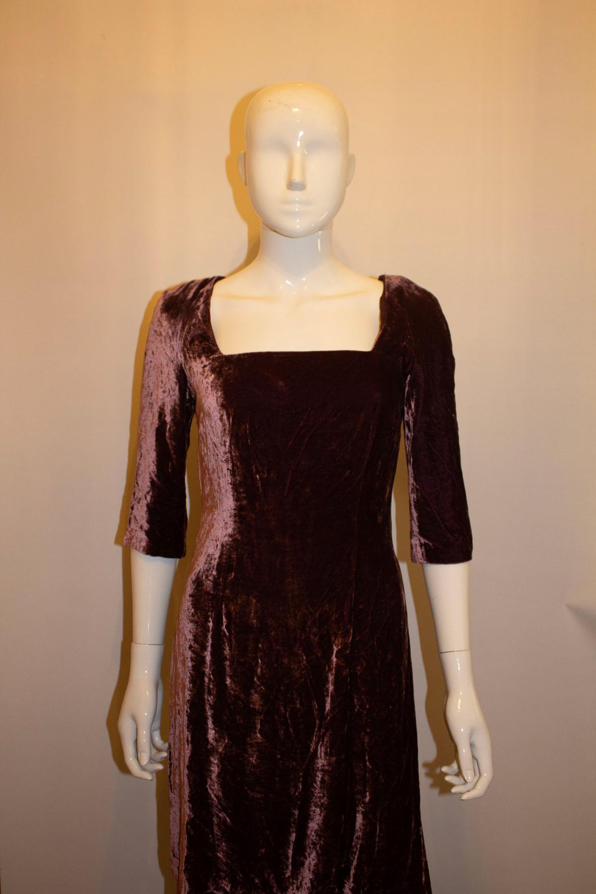An elegant silk velvet gown in a pretty plum colour by Paule Vasseur Paris. The dress  has a square neckline, back central zip and elbow length sleaves. It has tabard top on the upper area. Measurements: Bust 36'' length 55''