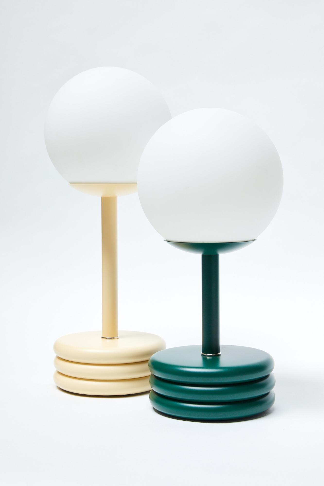 The Pluma lamp adds a fun pop of color and form to any room. Operated by a touch dimmer, with three brightness settings.

Lacquered brass with matte opal glass
10 ft. cloth covered cord, black
Wired for US 120V
E26 bulb base
Ships with