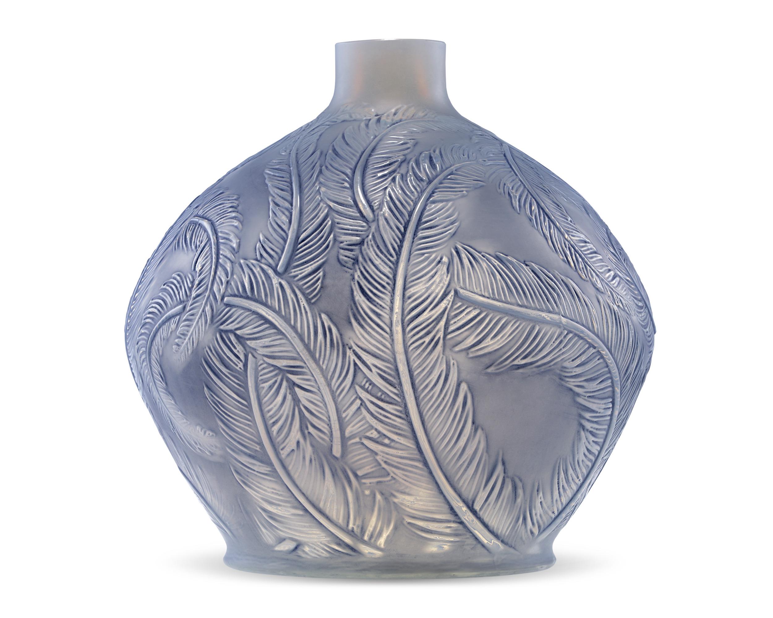Made by the legendary René Lalique, this art glass vase, crafted of opalescent and blue stained glass, celebrates nature. The design, created in 1920 and known as the Plumes vase, is enveloped in expertly etched intertwining feathers against a blue