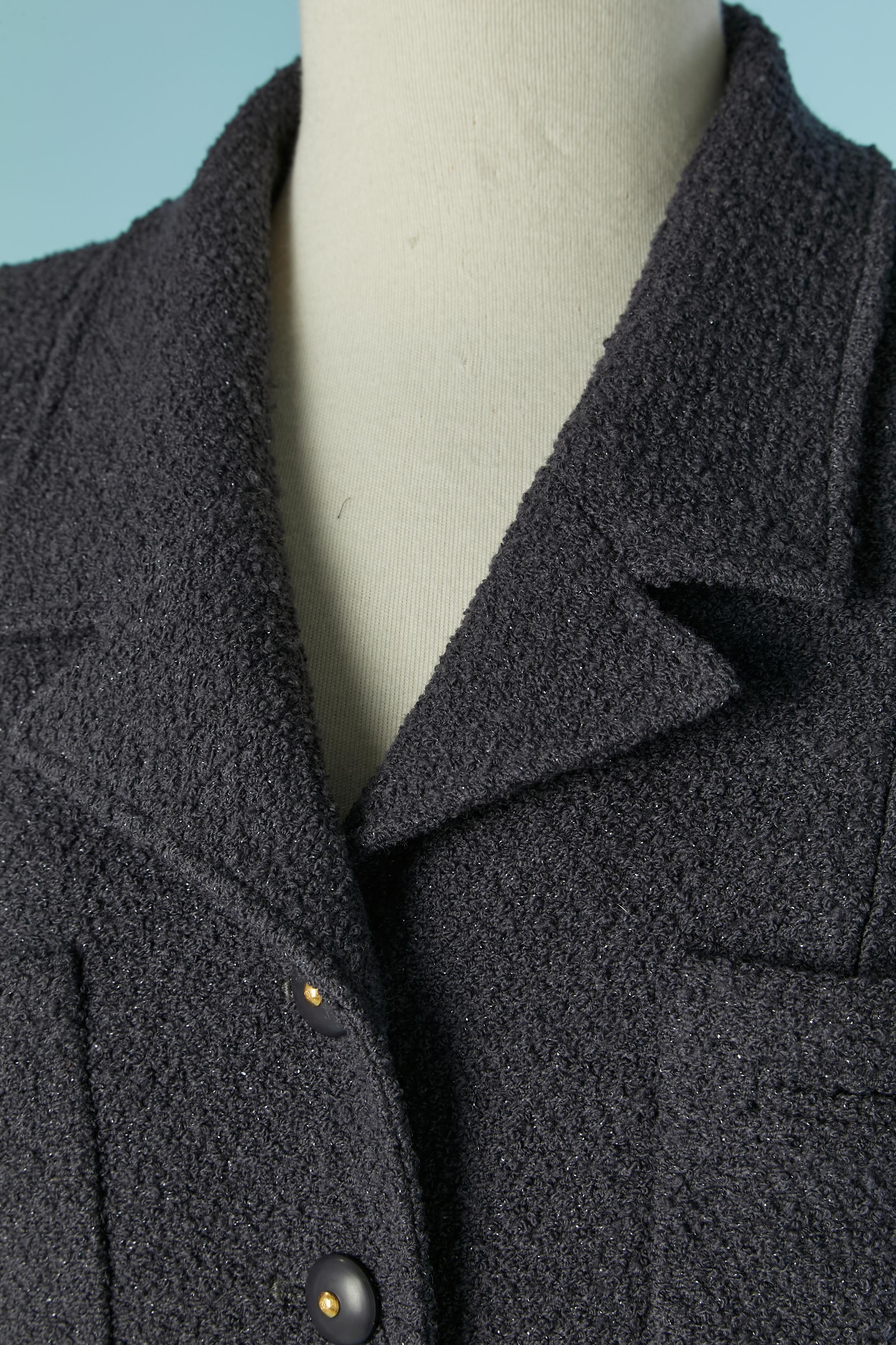 Giacca monopetto in tweed color prugna. L'etichetta della composizione del tessuto è stata tagliata, ma il tweed è probabilmente realizzato in lana e lurex o nylon (per un tocco di lucentezza). 
Fodera in seta con marchio. Spallaccio. Chiusura con