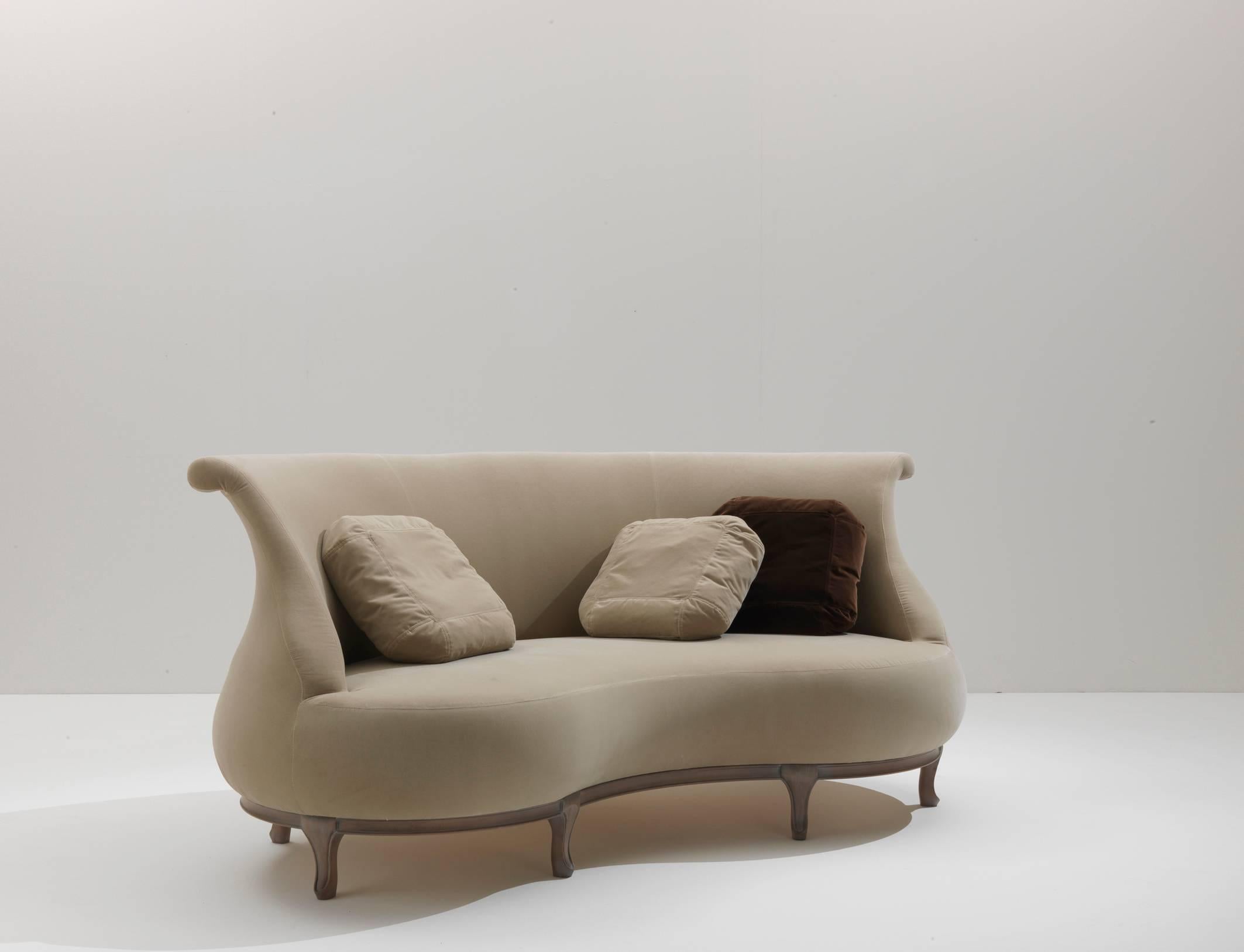 Wie der Plump-Sessel und der Pouffe ist auch dieses Sofa mit schlichten, geschwungenen Linien auf einem Holzgestell ausgestattet. Seine Bohnenform sorgt für perfekte Entspannung und gute Unterhaltung. Die Sitzenden können sich einander zuwenden oder