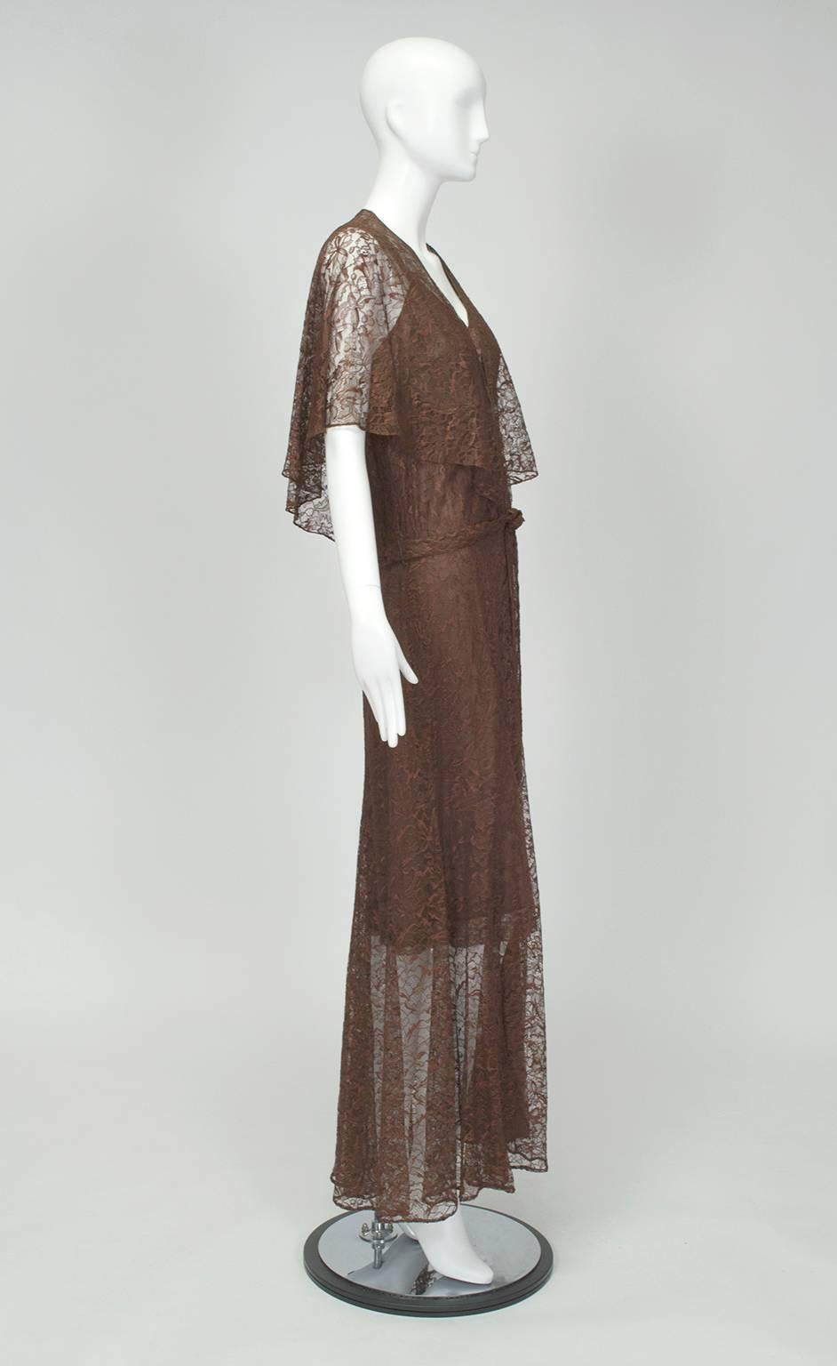 In true Hollywood Regency style, this gown technically covers the body but would leave little to the imagination if it weren't for the slip worn underneath. Despite having yards of fabric, its fluttering capelet and navel-grazing neck plunge convey