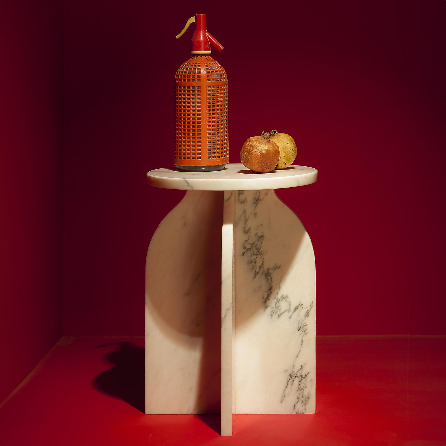 The Plus Side Table is a minimalist style side table made of treated Portuguese pink marble. This side table is composed of a circular marble top, supported by four marble plates forming two pointed arches in positive. All of the elements are
