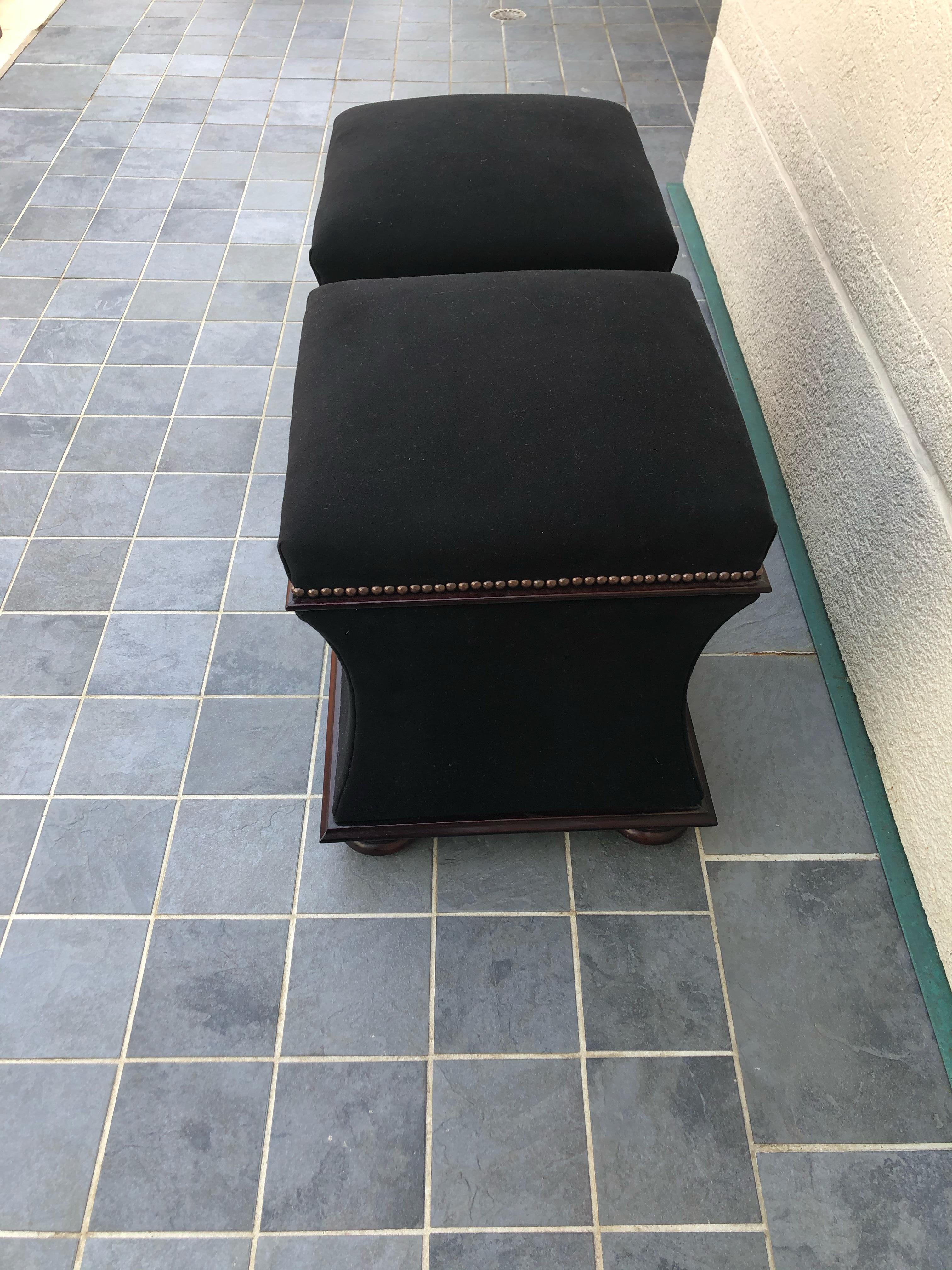 Fabulous pair of George smith storage ottomans foot stools. Striking black velvet mohair fabric with nail head trim and bun feet.  Both tops open to reveal handy storage inside.