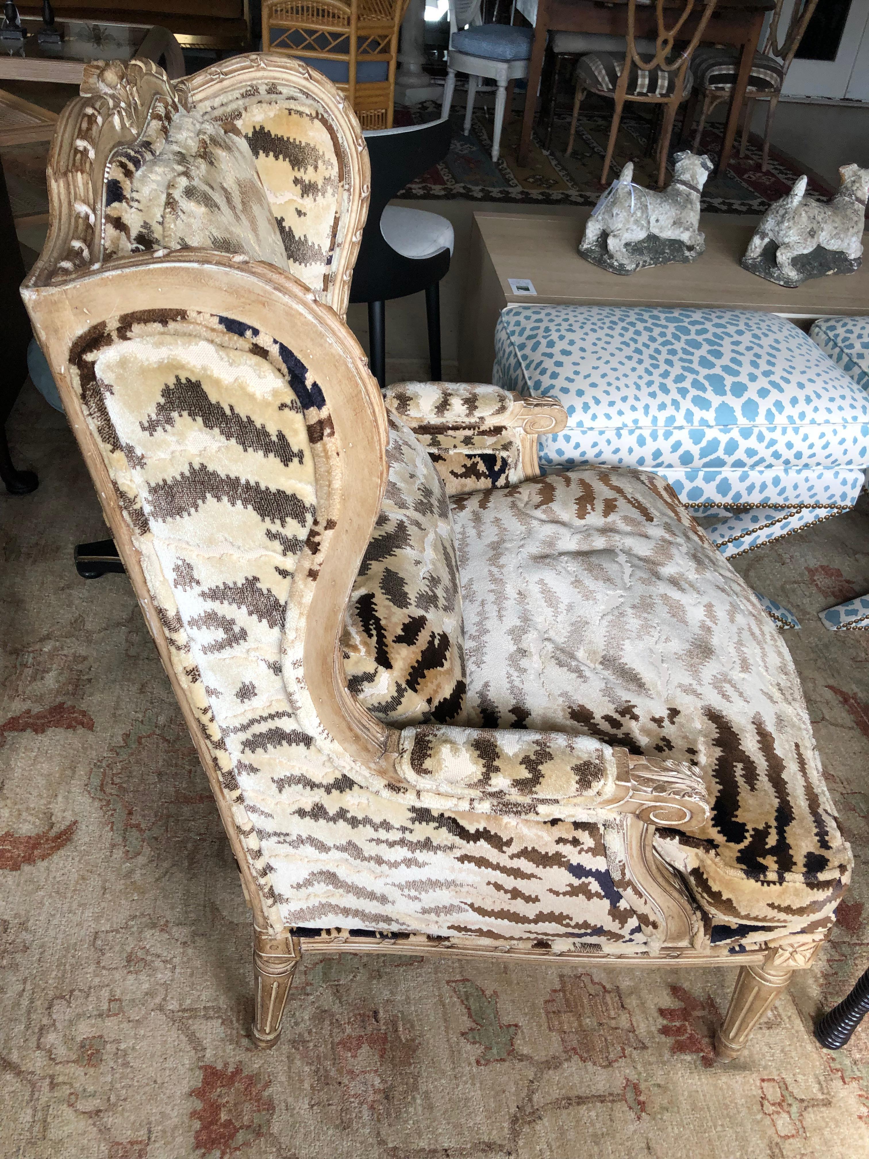 Plush vintage upholstered and carved wood French style wing chair having beige painted frame and animal print cut velvet upholstery in taupe, gold and greige (grey and beige).  Seat is down filled and like sitting on a cloud.  Label says Ralph