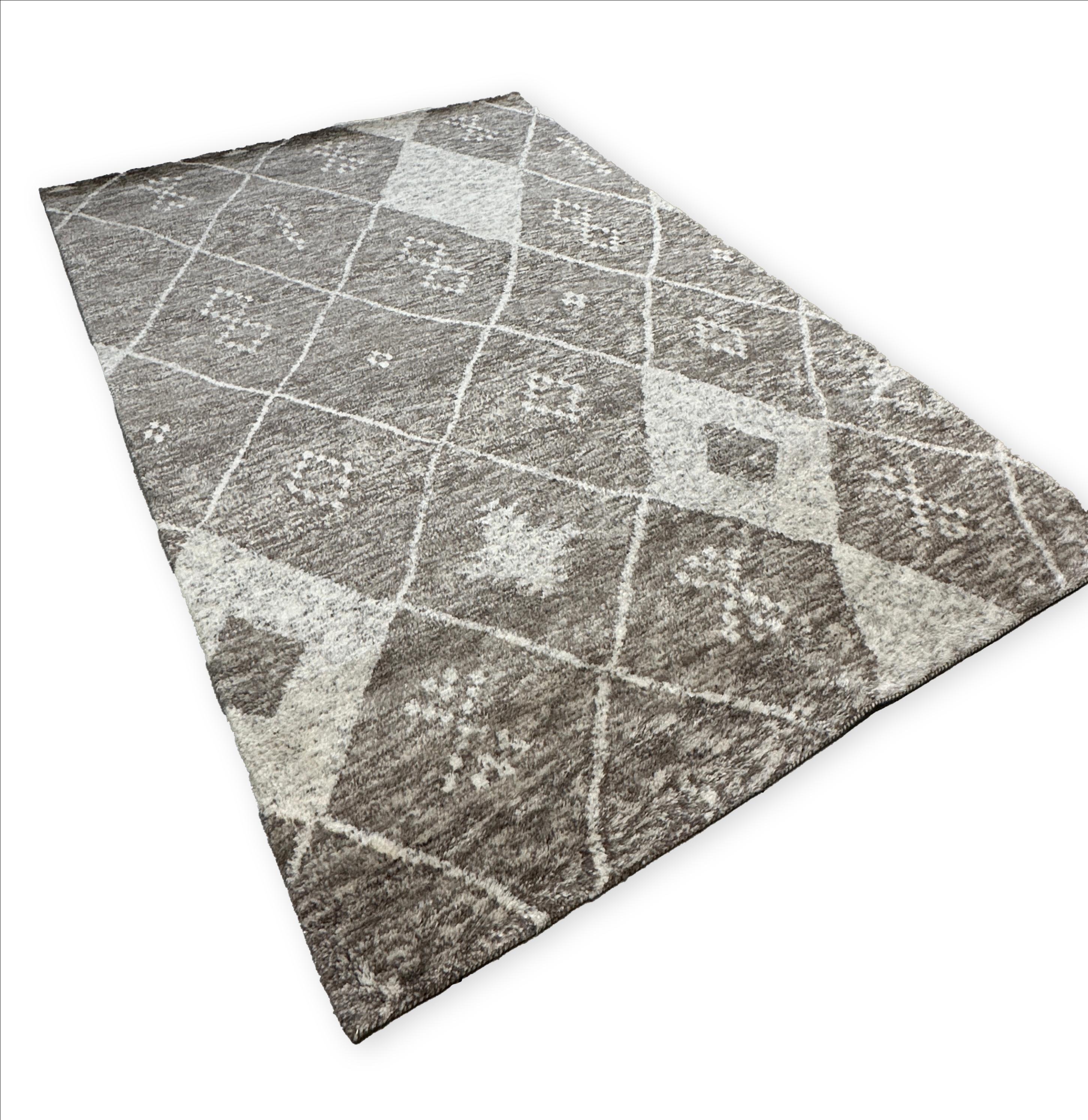 Elevate your home décor with the Plush Moroccan Rug, showcasing a mesmerizing concentric diamond pattern. This luxurious rug effortlessly blends traditional Moroccan artistry with contemporary design, featuring a harmonious palette of beige and