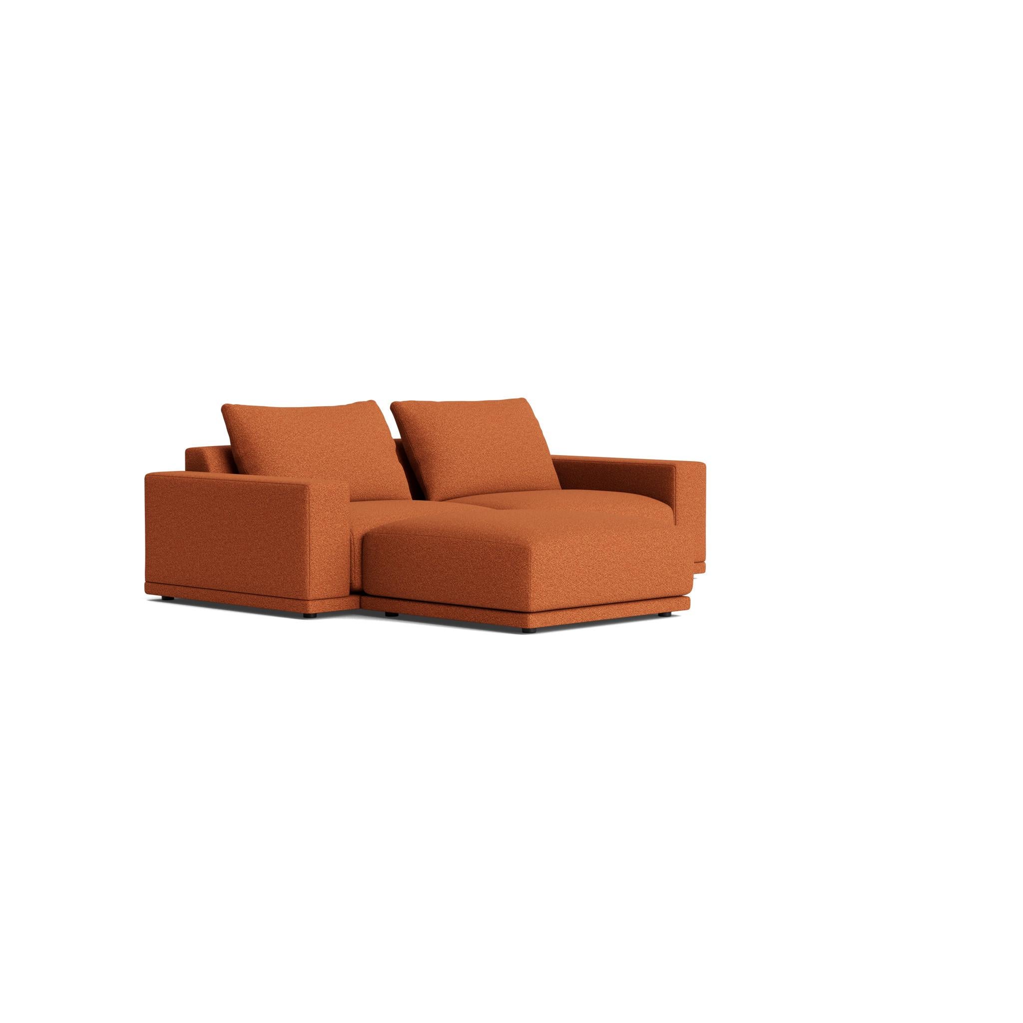 The Geometric Modern armchair exudes understated elegance. Its extra-wide, rectilinear arms are adorned with relaxed throw pillows, all resting on a single, seamless bench seat—chic and effortlessly comfortable.