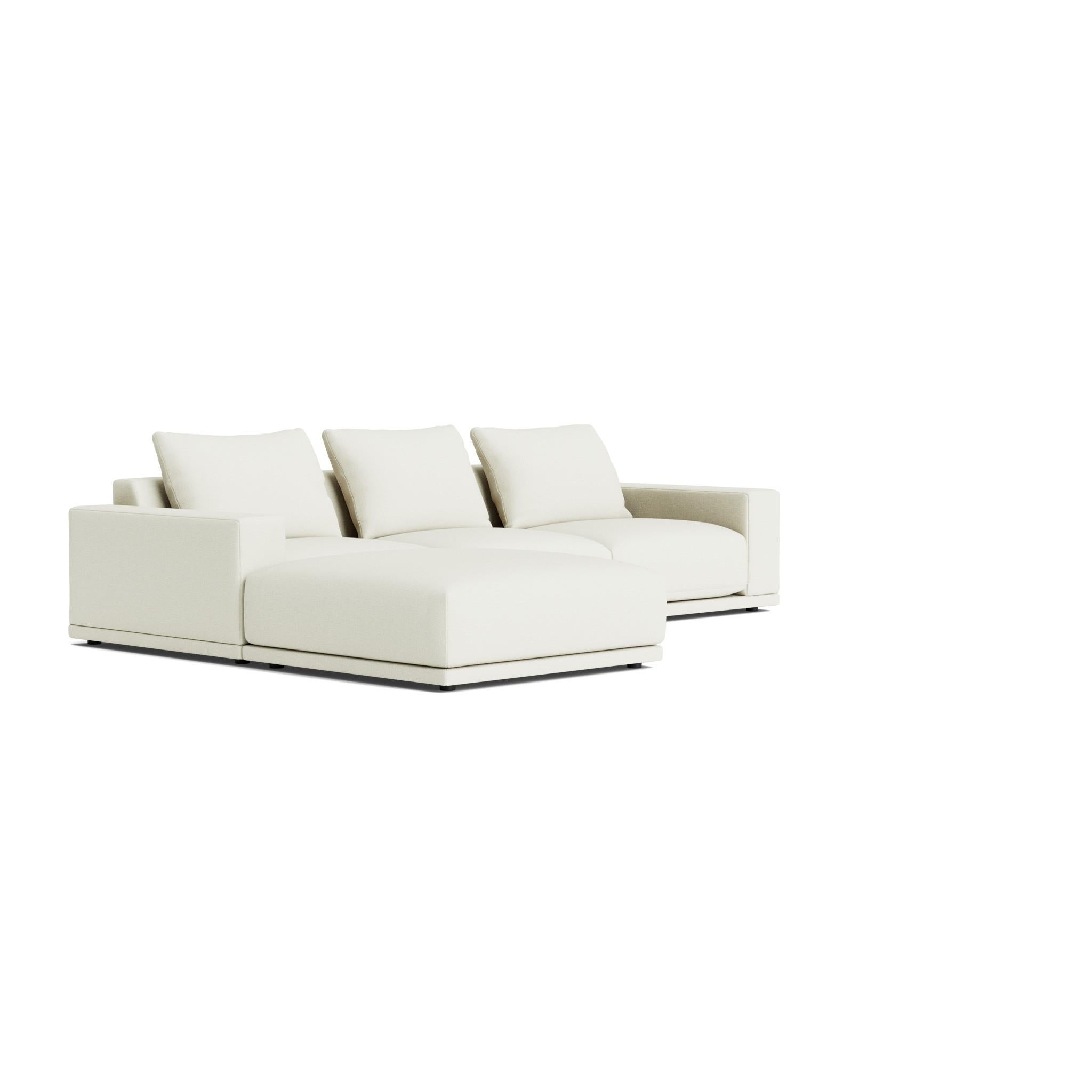 The Geometric Modern armchair exudes understated elegance. Its extra-wide, rectilinear arms are adorned with relaxed throw pillows, all resting on a single, seamless bench seat—chic and effortlessly comfortable.
