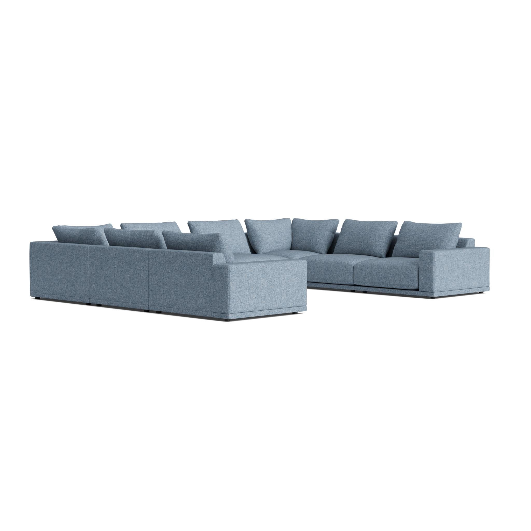 The Geometric Modern armchair exudes understated elegance. Its extra-wide, rectilinear arms are adorned with relaxed throw pillows, all resting on a single, seamless bench seat—chic and effortlessly comfortable.