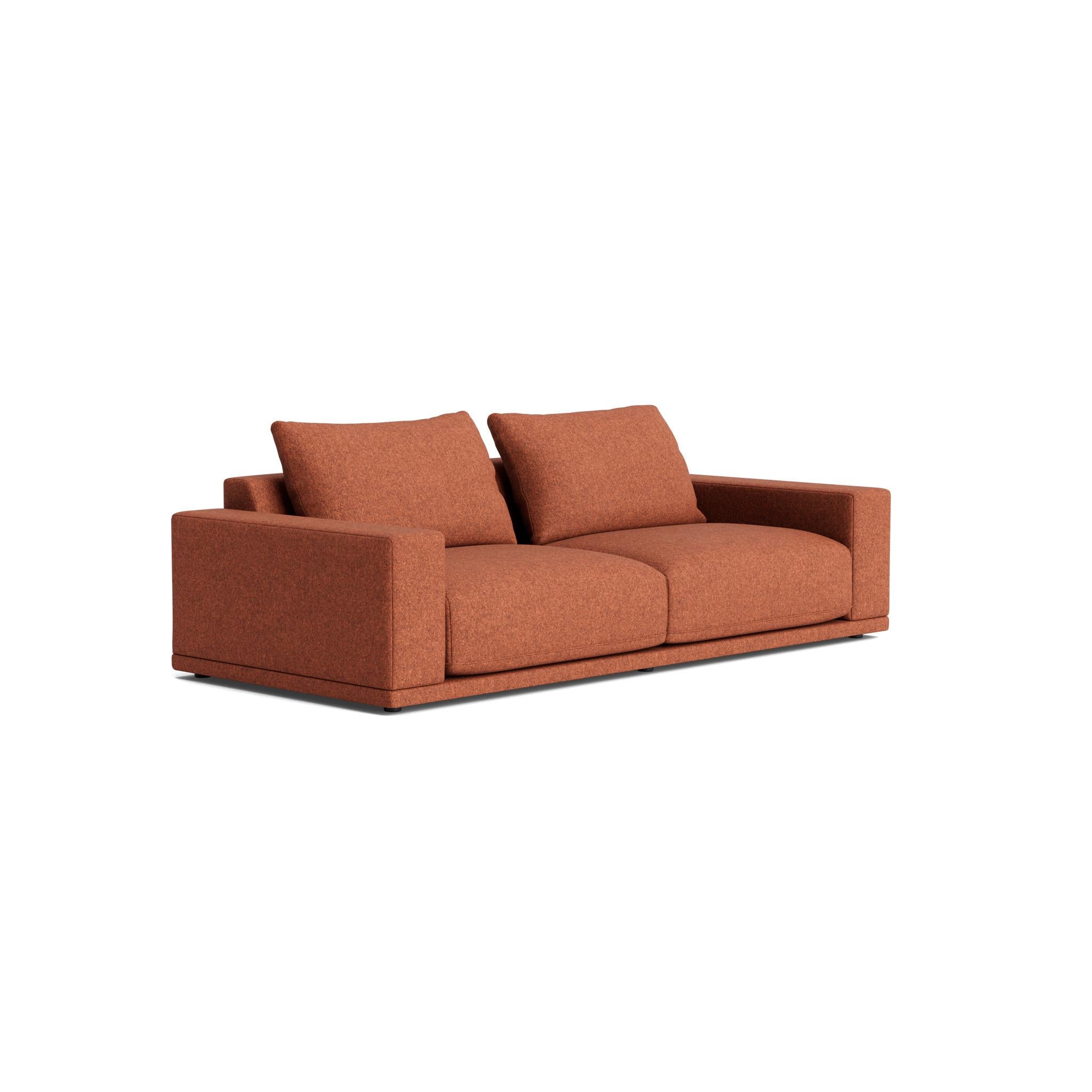 The Geometric Modern armchair exudes understated elegance. Its extra-wide, rectilinear arms are adorned with relaxed throw pillows, all resting on a single, seamless bench seat—chic and effortlessly comfortable.