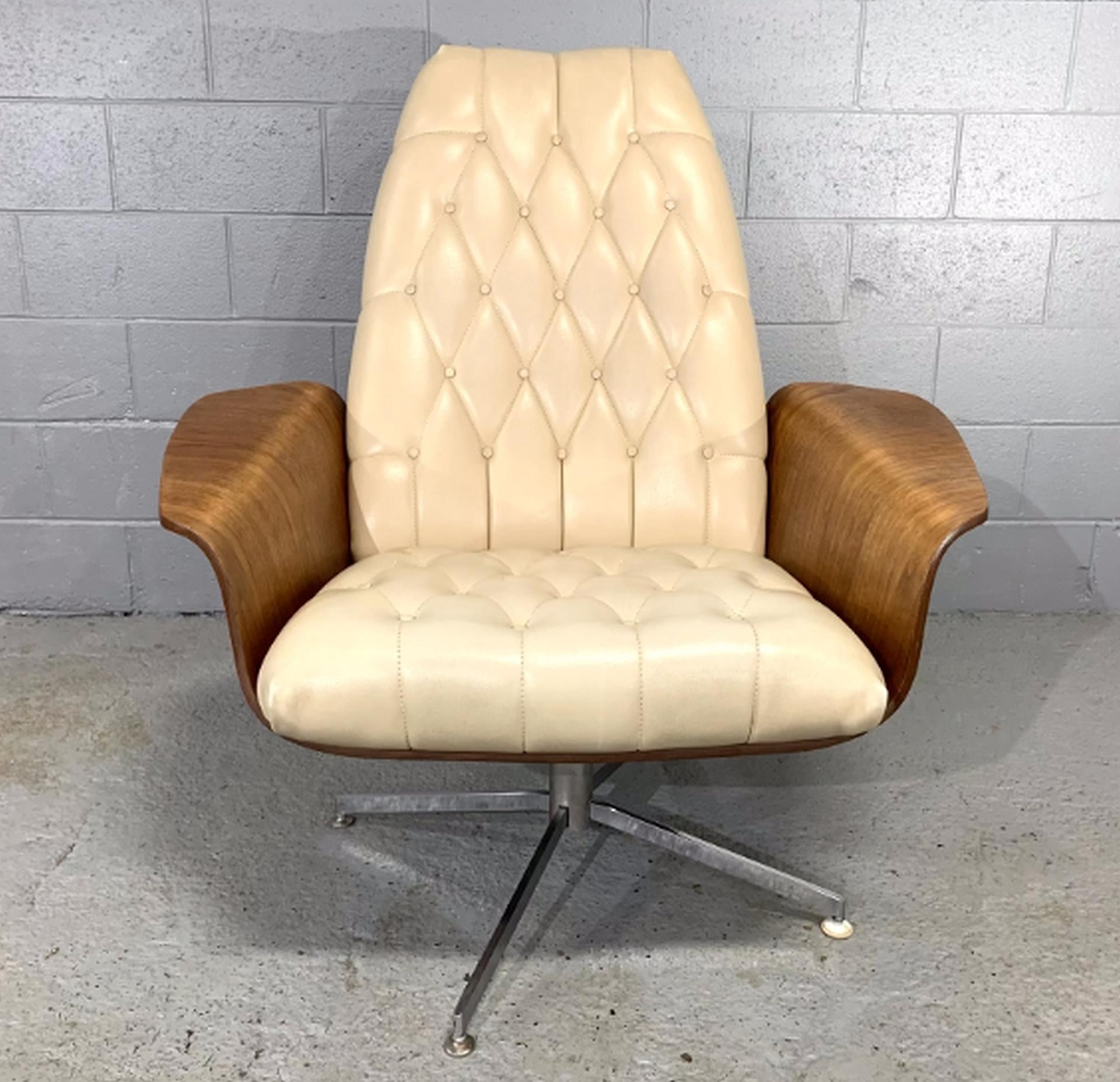 Teak lounge chair with high quality cream leather upholstery and swivel base by George Mulhauser for Plycraft. Called the “Mr. Chair”, this swivel lounge chair features a bentwood teak shell with winged armrests and a metal x-style base. It swivels